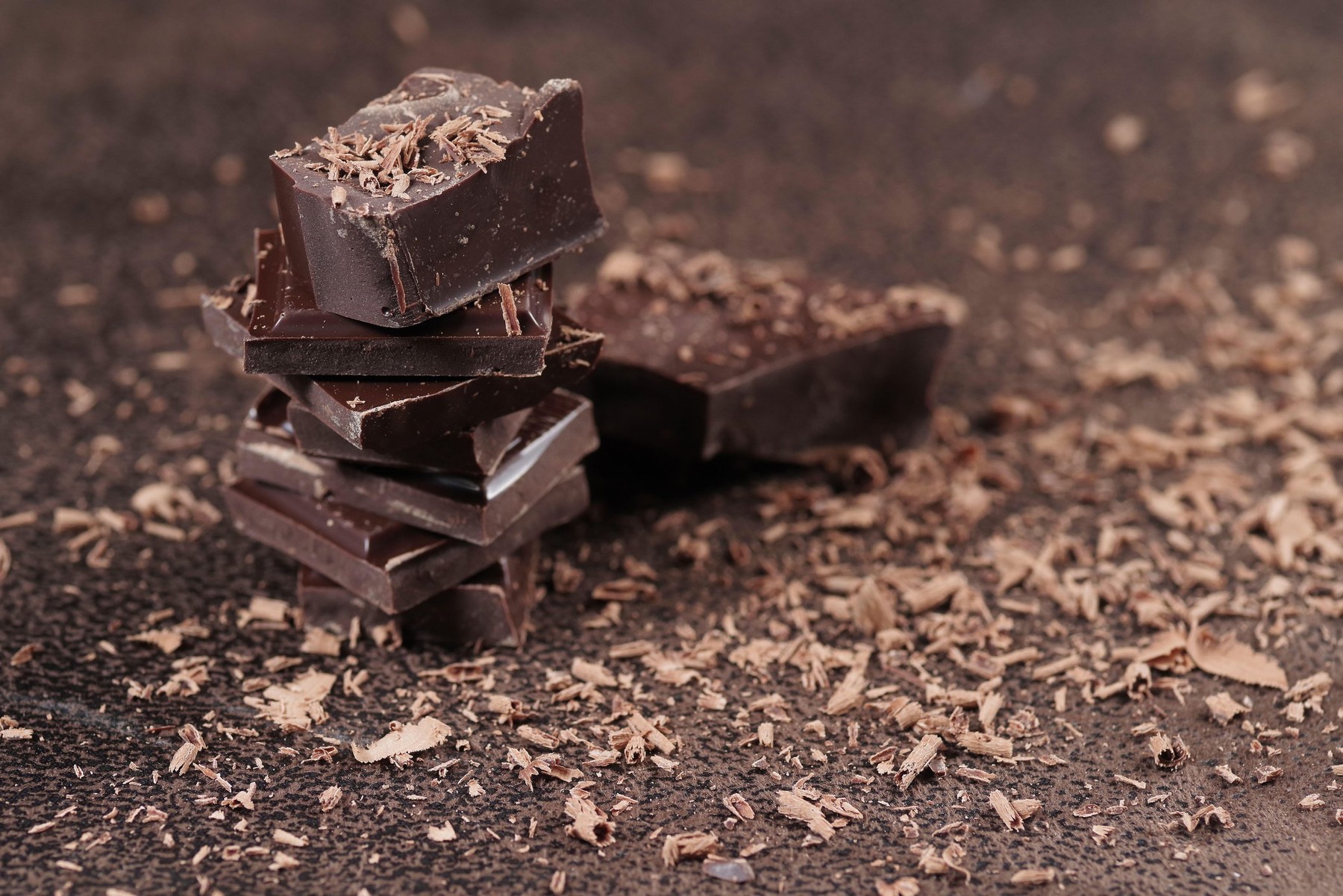 Broken dark chocolate and cocoa powder on a table