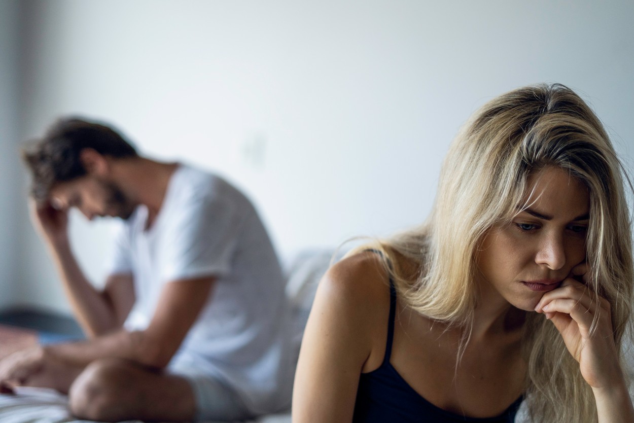 Upset couple sitting in bedroom