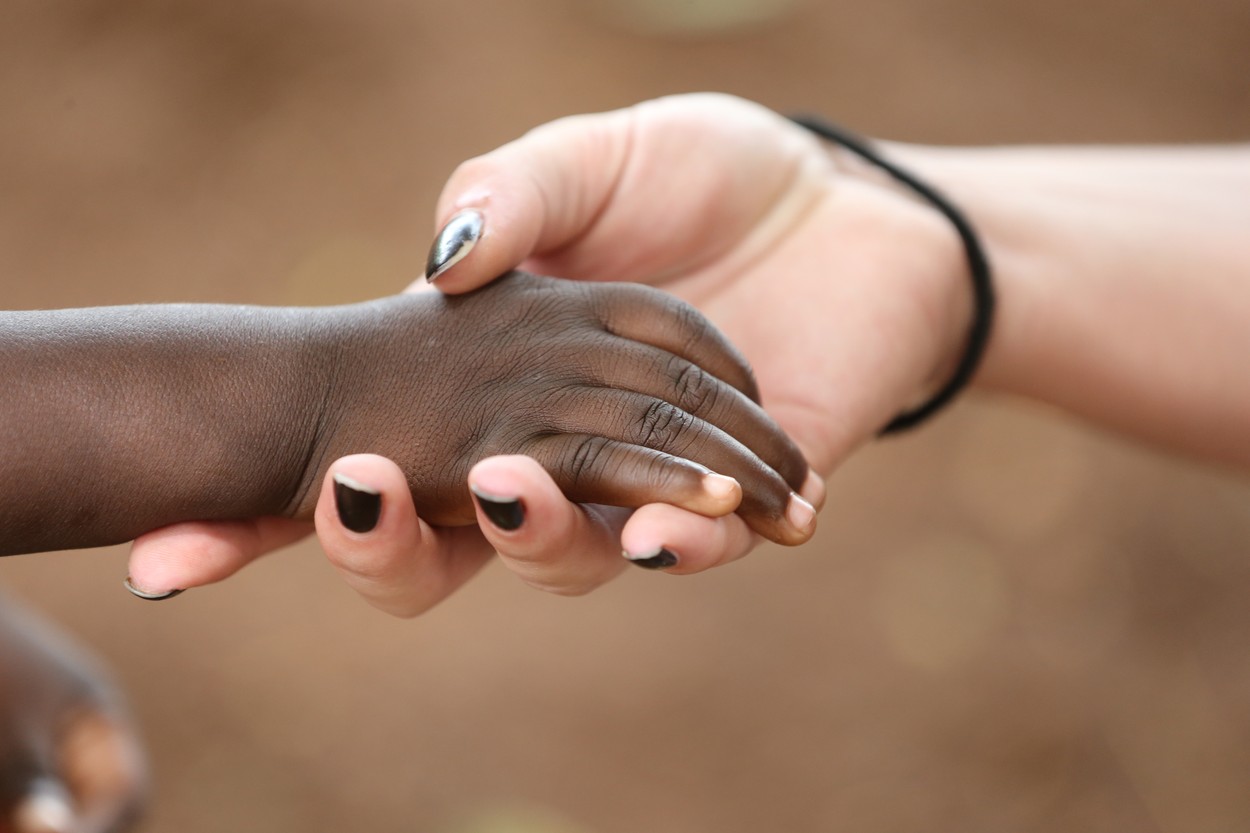 Humanitarian worker holding child's hand. togo.