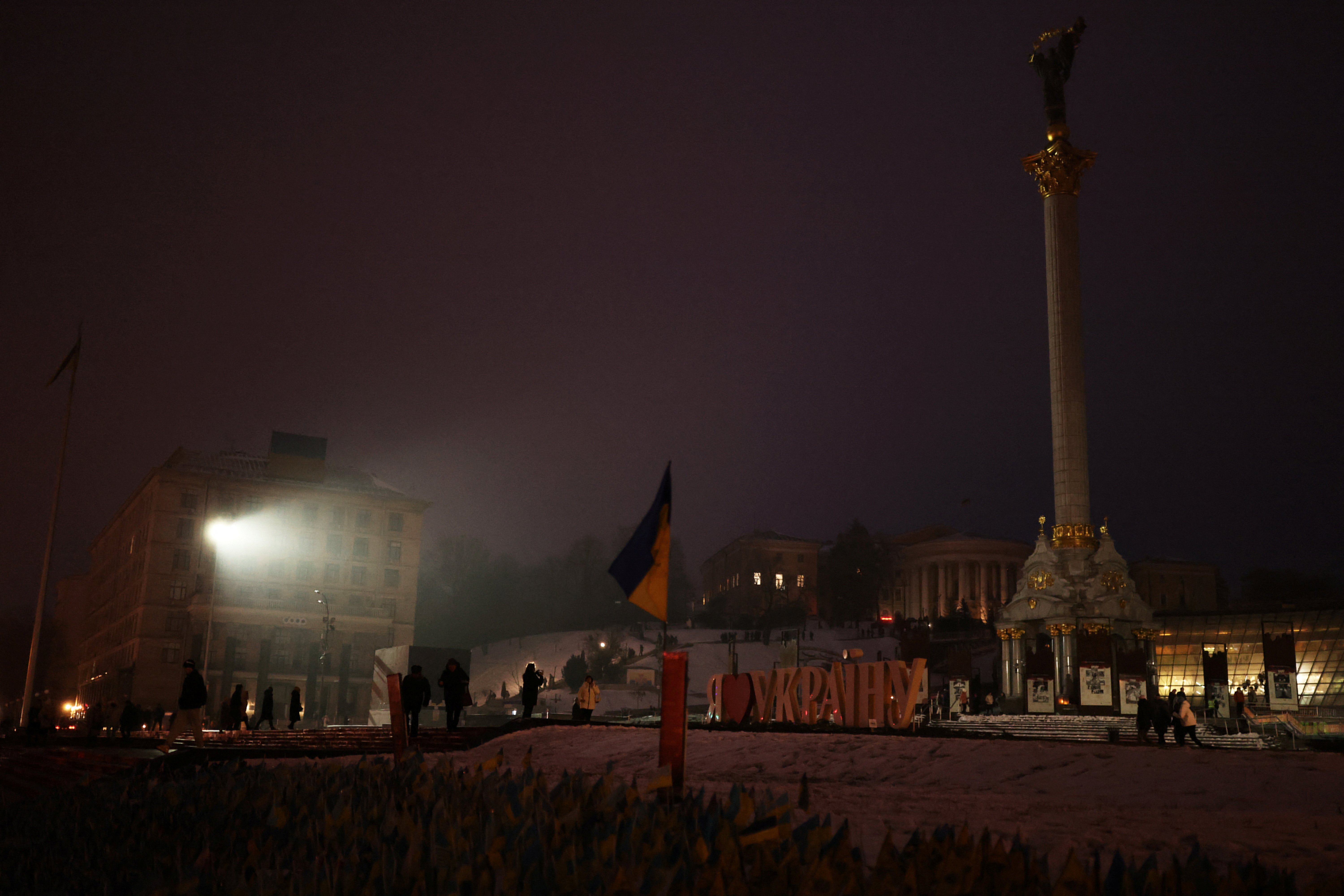 A woman takes a picture of a friend in front of 'I Love Ukraine sign' in Maidan Nezalezhnosti, amid Russia's invasion of Ukraine, in central in Kyiv