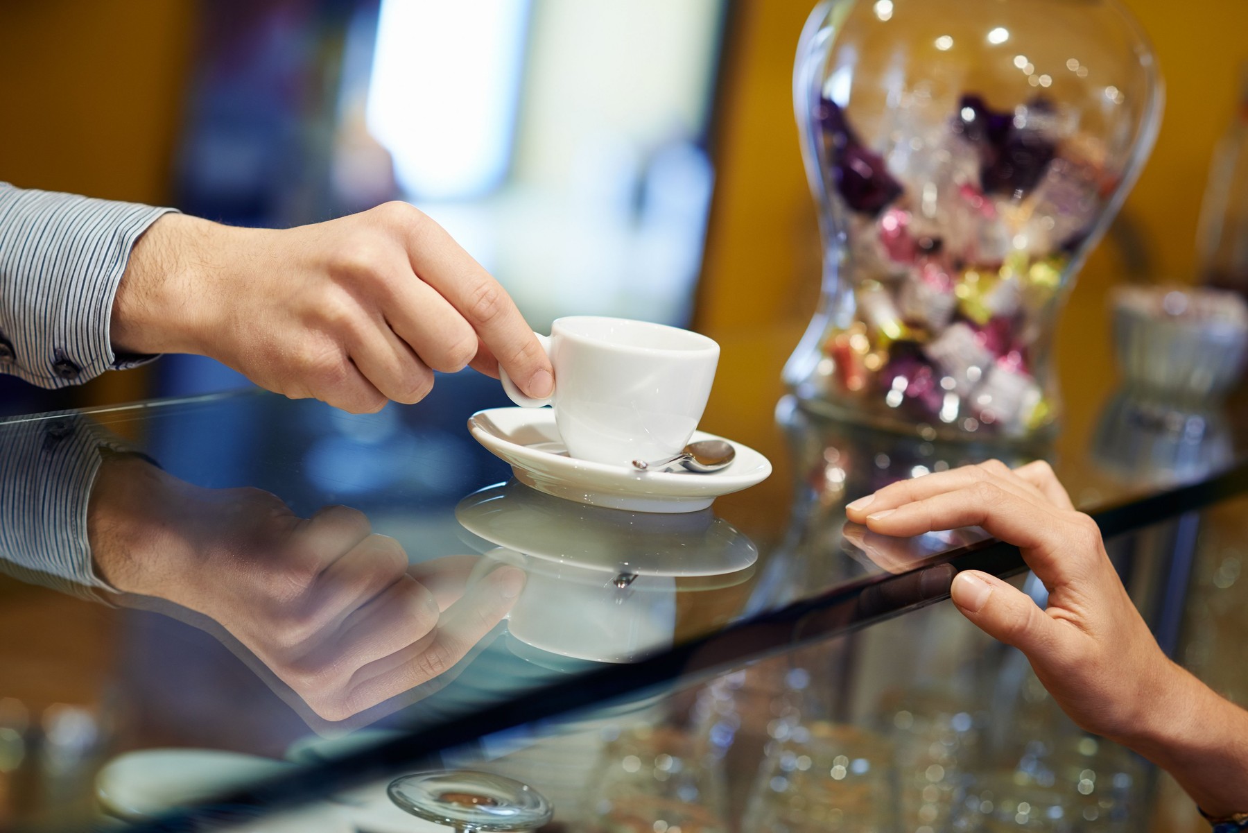 People in bar with female client drinking espresso coffee and barman serving cup