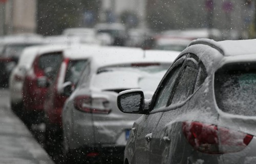 Cars covered in snow after a cold day.
