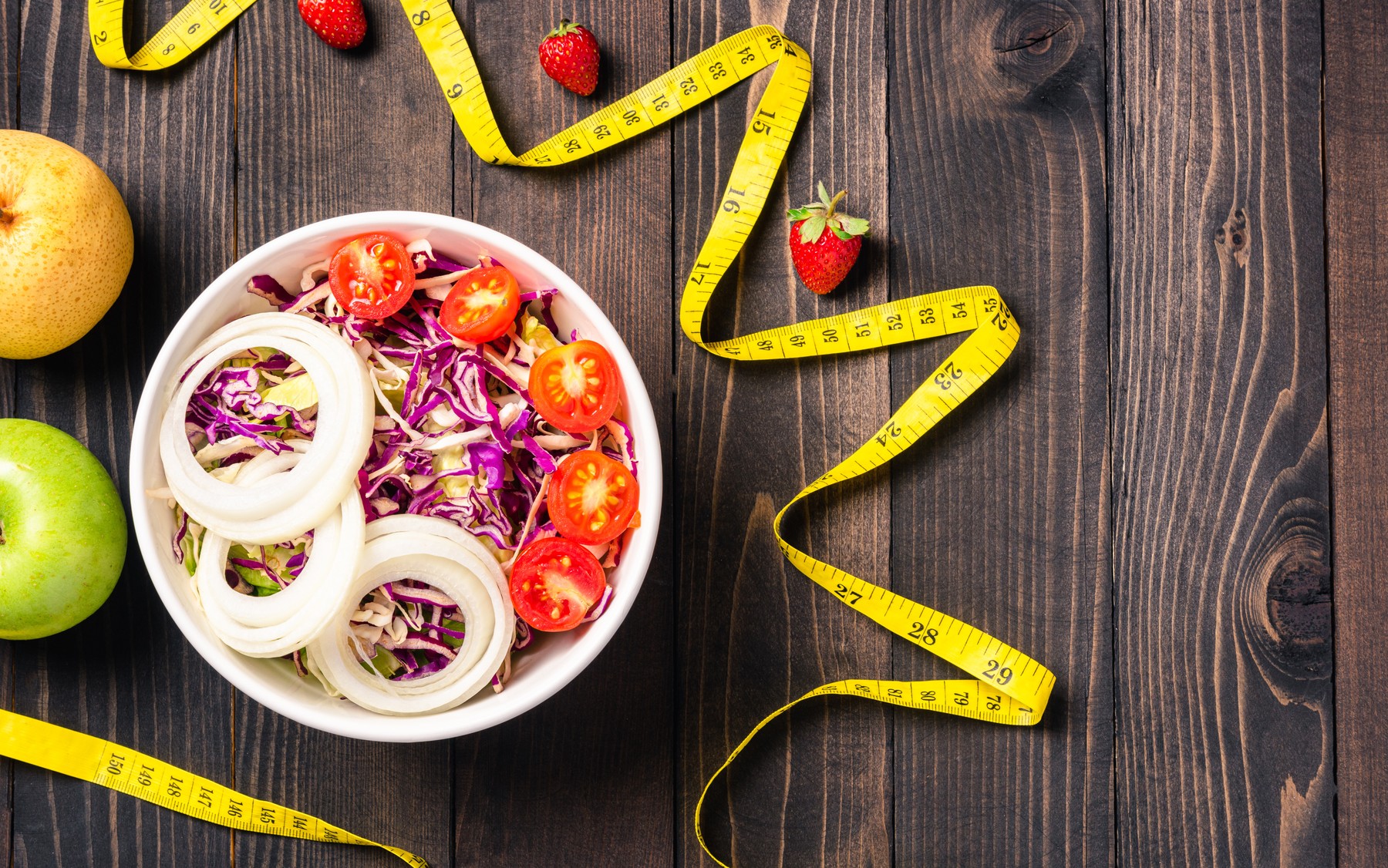 salad bowl with tomatoes fresh mixed greens vegetable in a dish and measuring tape