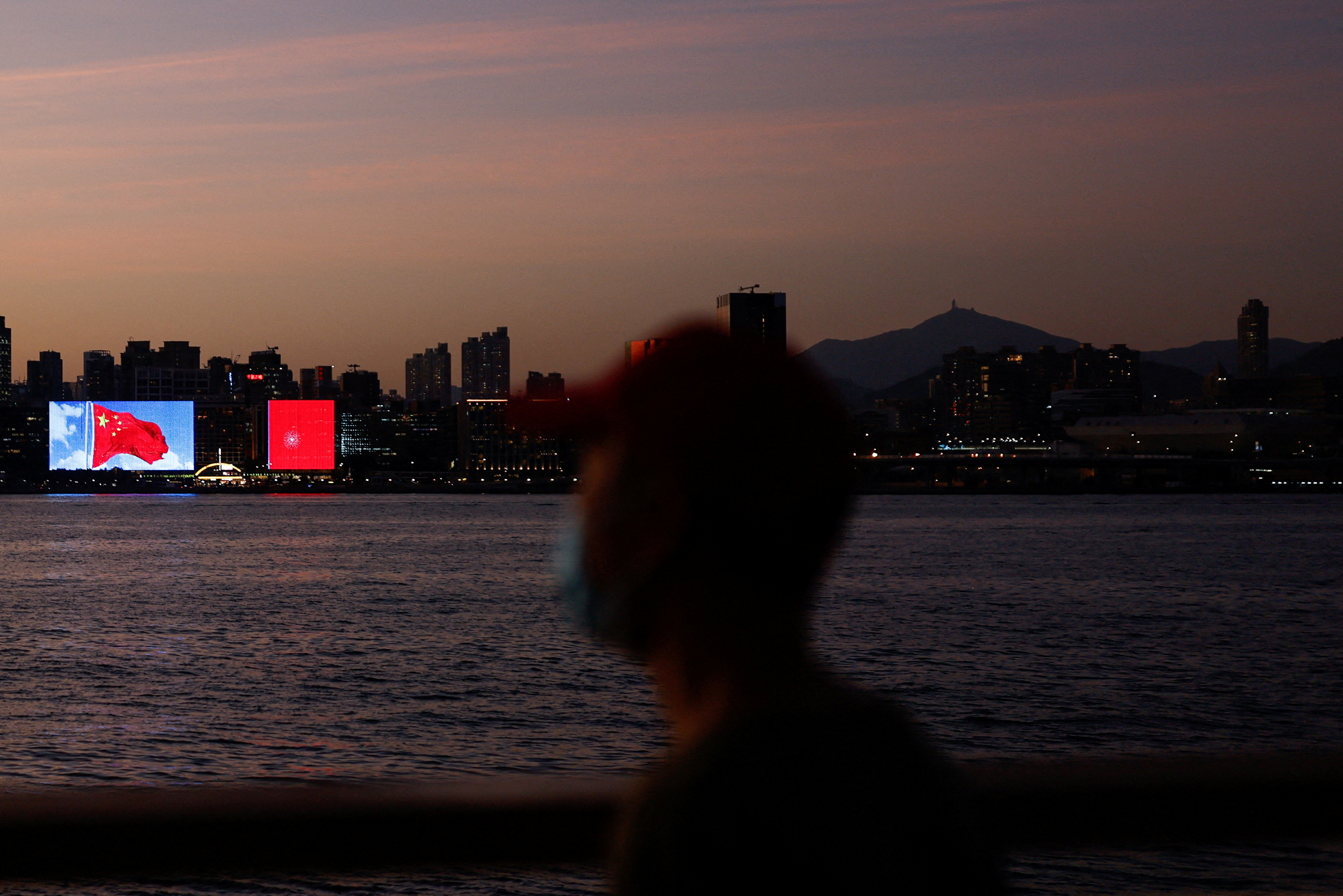 FILE PHOTO: The Chinese flag is seen across the Victoria Harbour during sunset, in Hong Kong