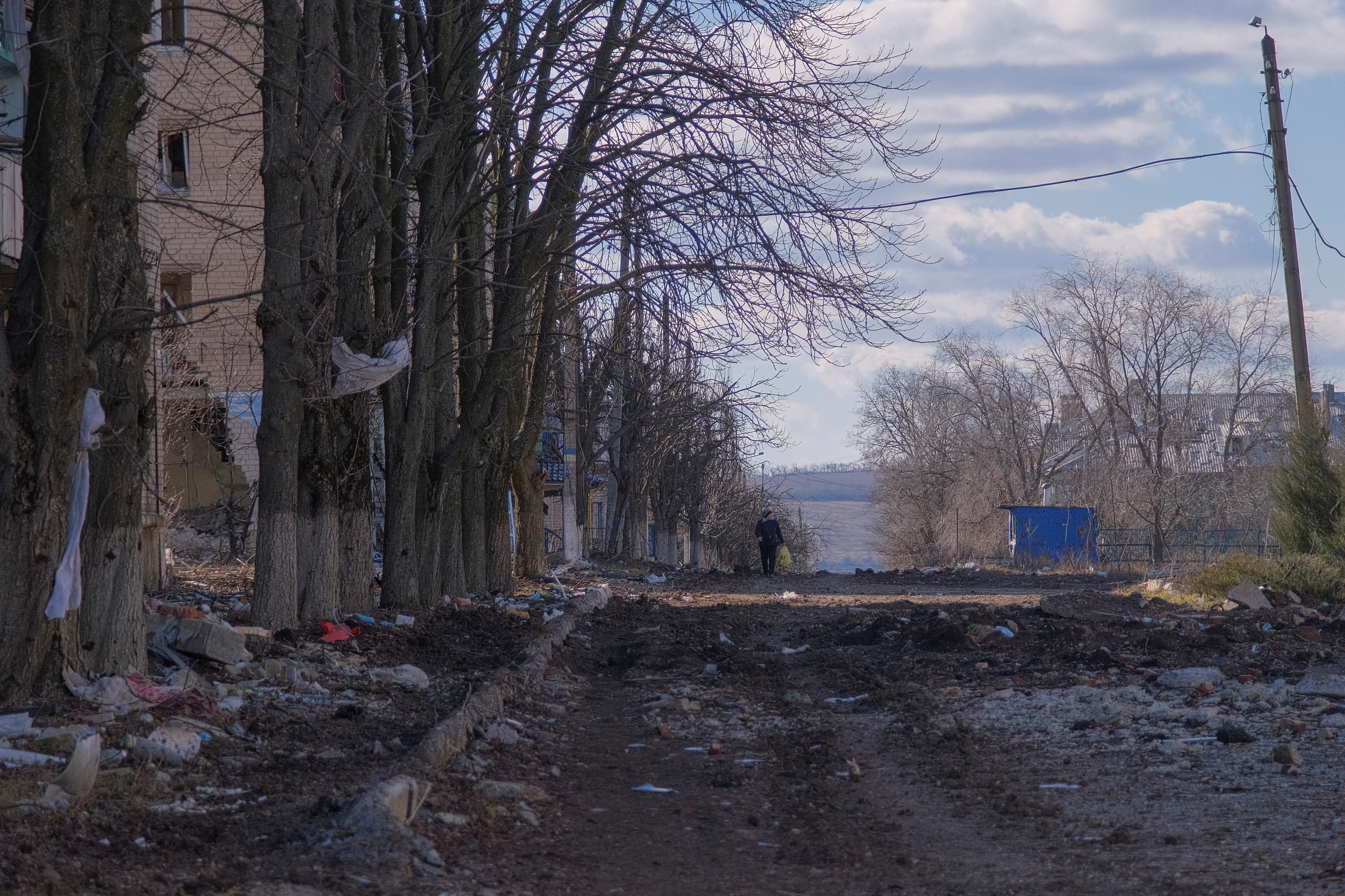 Local resident walks along damaged street in the town of Siversk