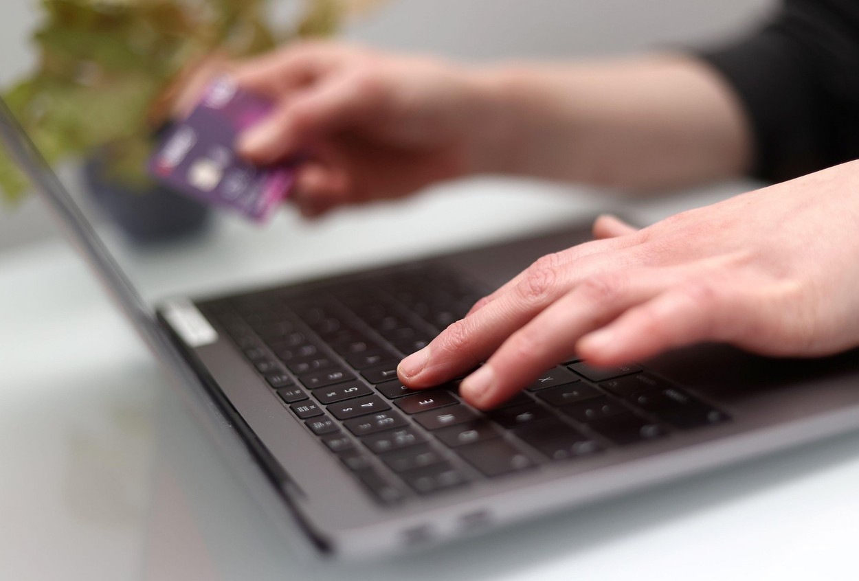 File photo dated 30/03/2020 of a woman using a laptop as she holds a bank card. Google's Chrome web browser is only preventing users from visiting around a quarter of suspicious sites that are likely part of phishing scams, Which? has claimed. Issue date: