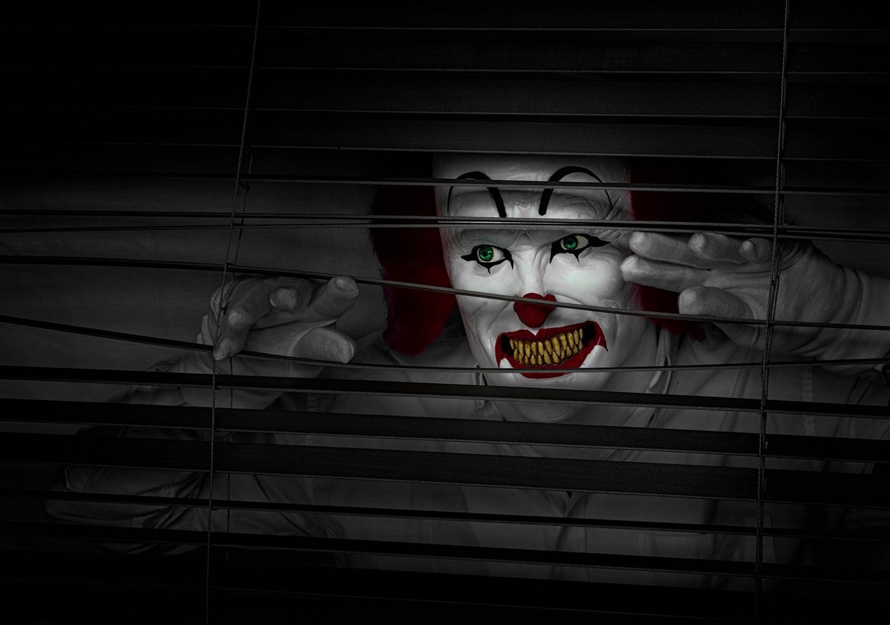 Scary horror clown looking through window