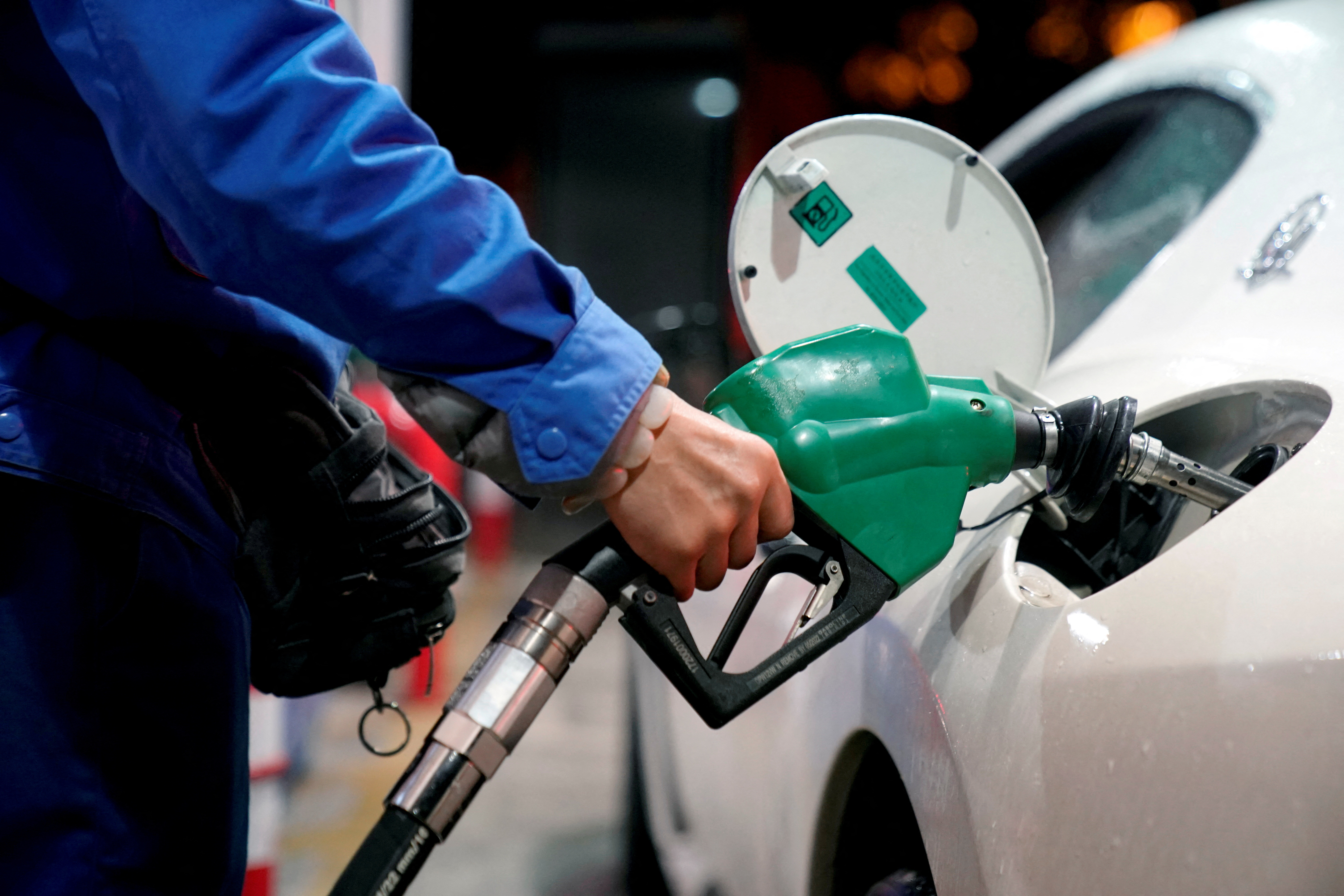 FILE PHOTO: A gas station attendant pumps fuel into a customer's car at a gas station in Shanghai