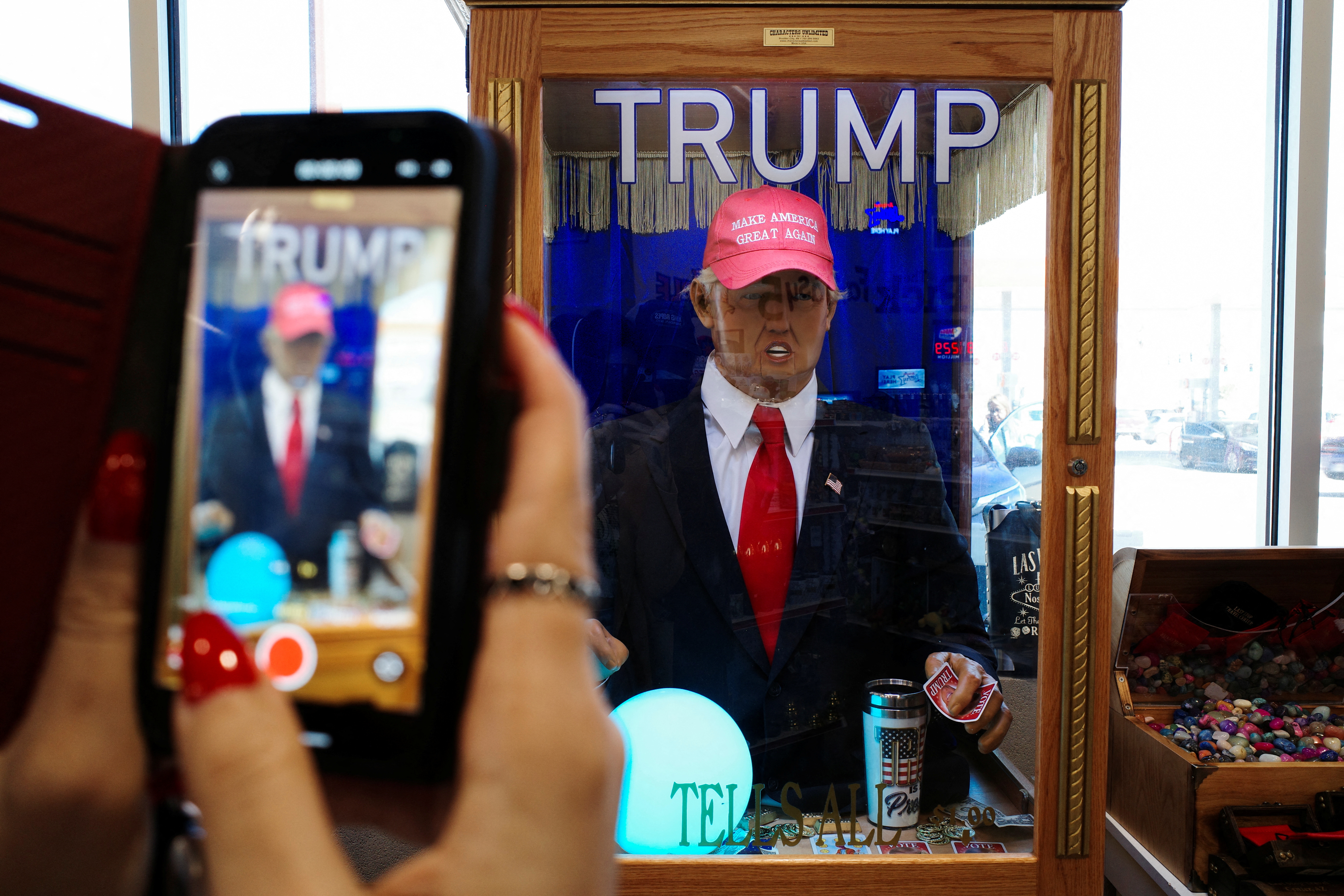 A woman uses her iPhone to record a talking Donald Trump fortune teller machine inside the Arizona Last Stop Travel Center in White Hills