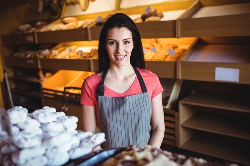Portrait of female baker smiling in bakery shop