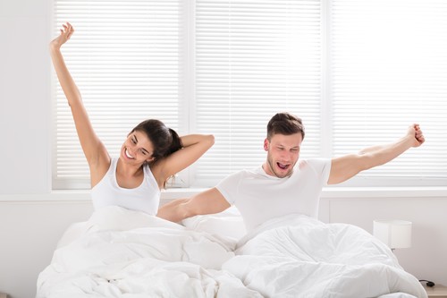 Happy Couple Waking Up On Bed