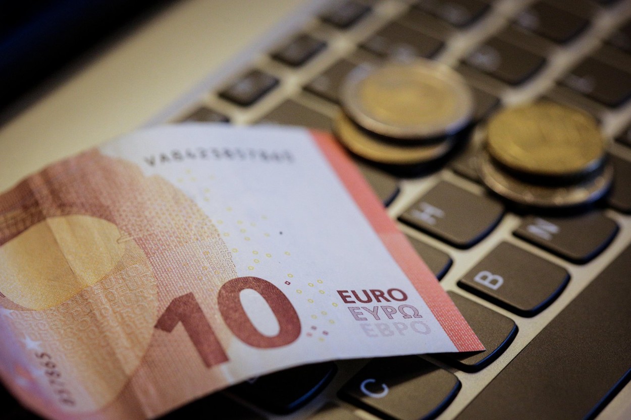 Euro coins on laptop's keyboard - make money online