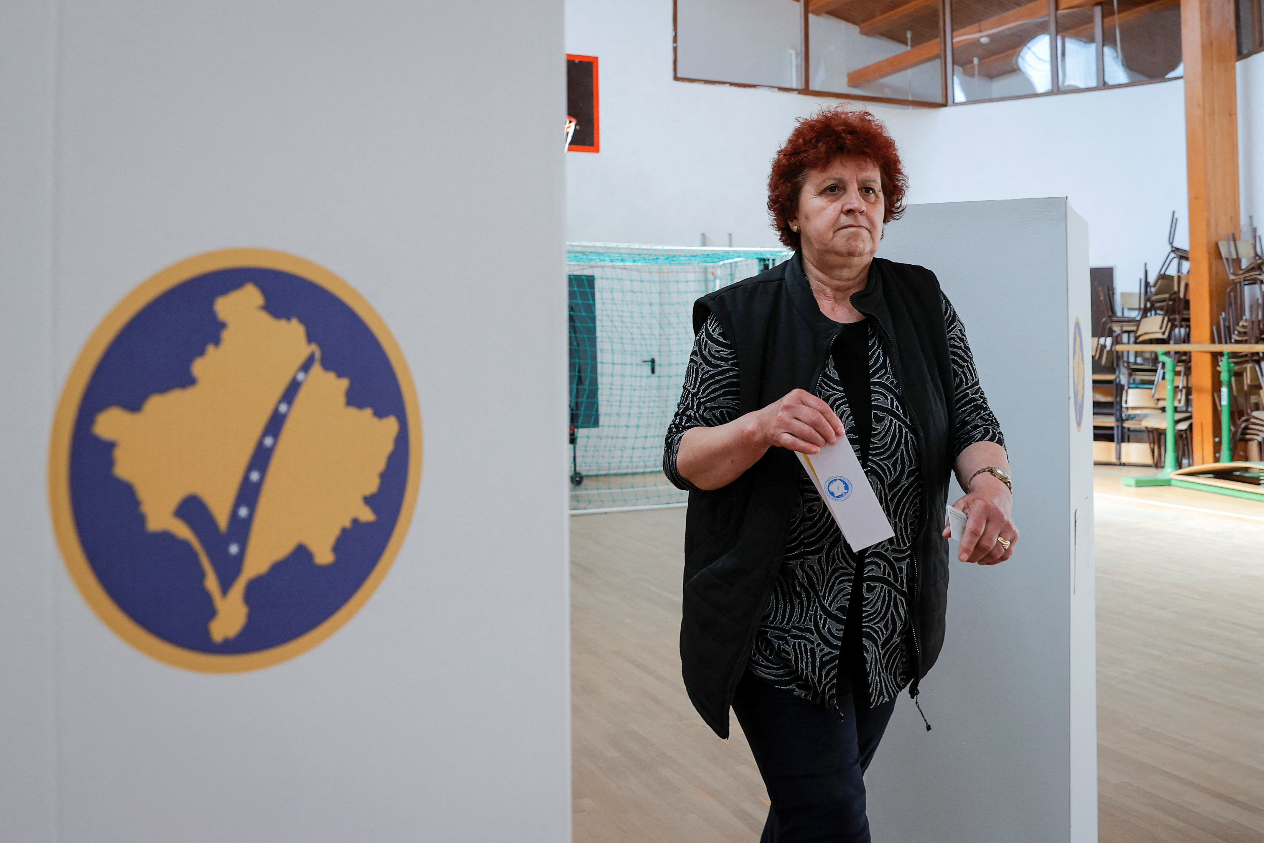 A Kosovo Albanian woman prepares to vote at a polling station in the village of Qabra