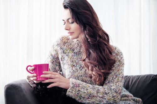 Woman drinking coffee on sofa
