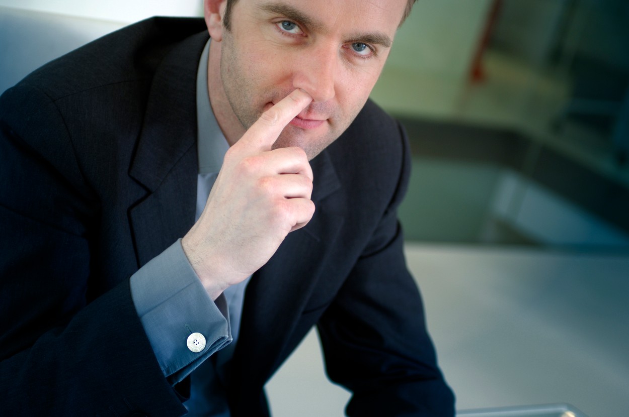 portrait of businessman picking his nose