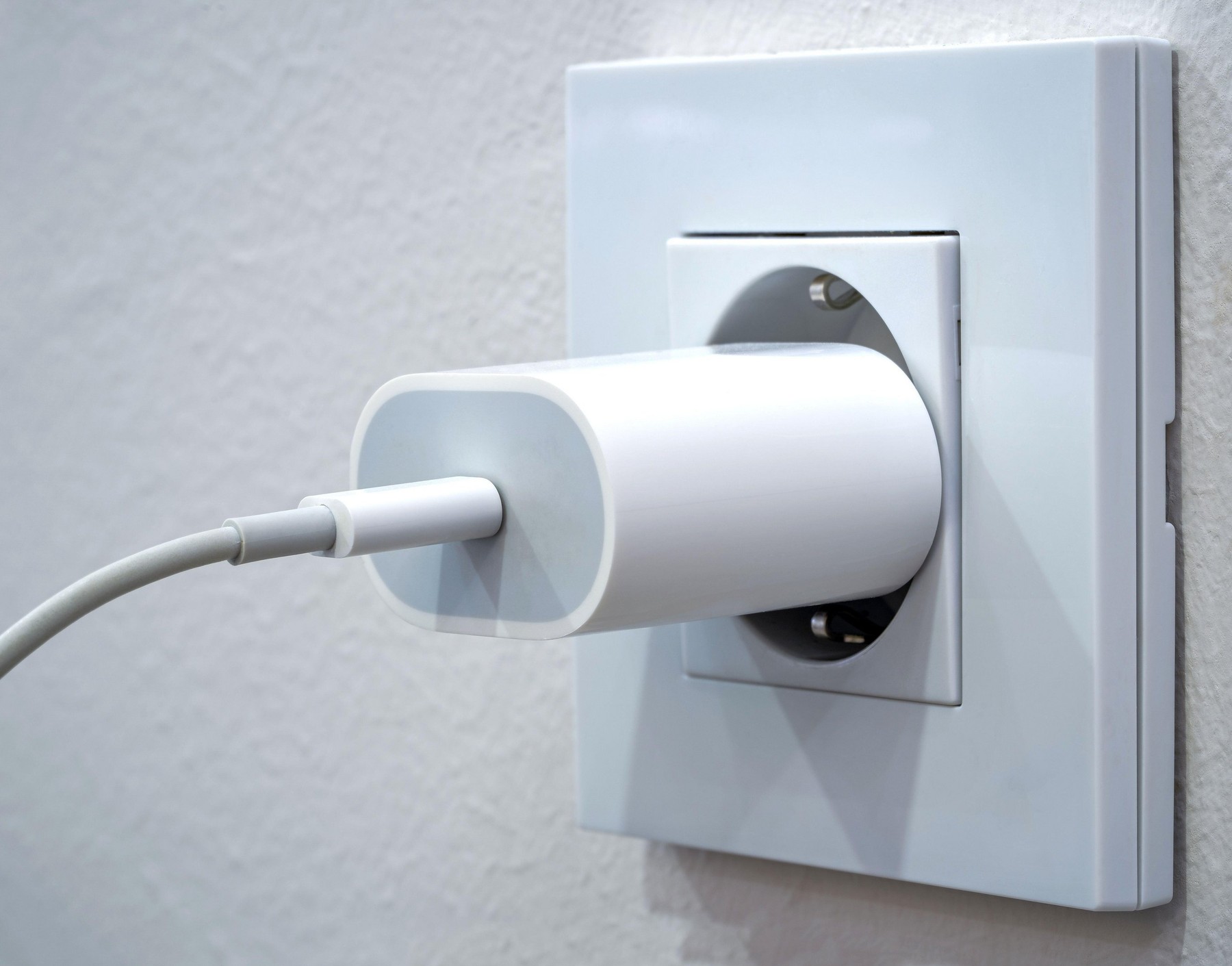 Close up of a mobile phone charger plugged into an outlet