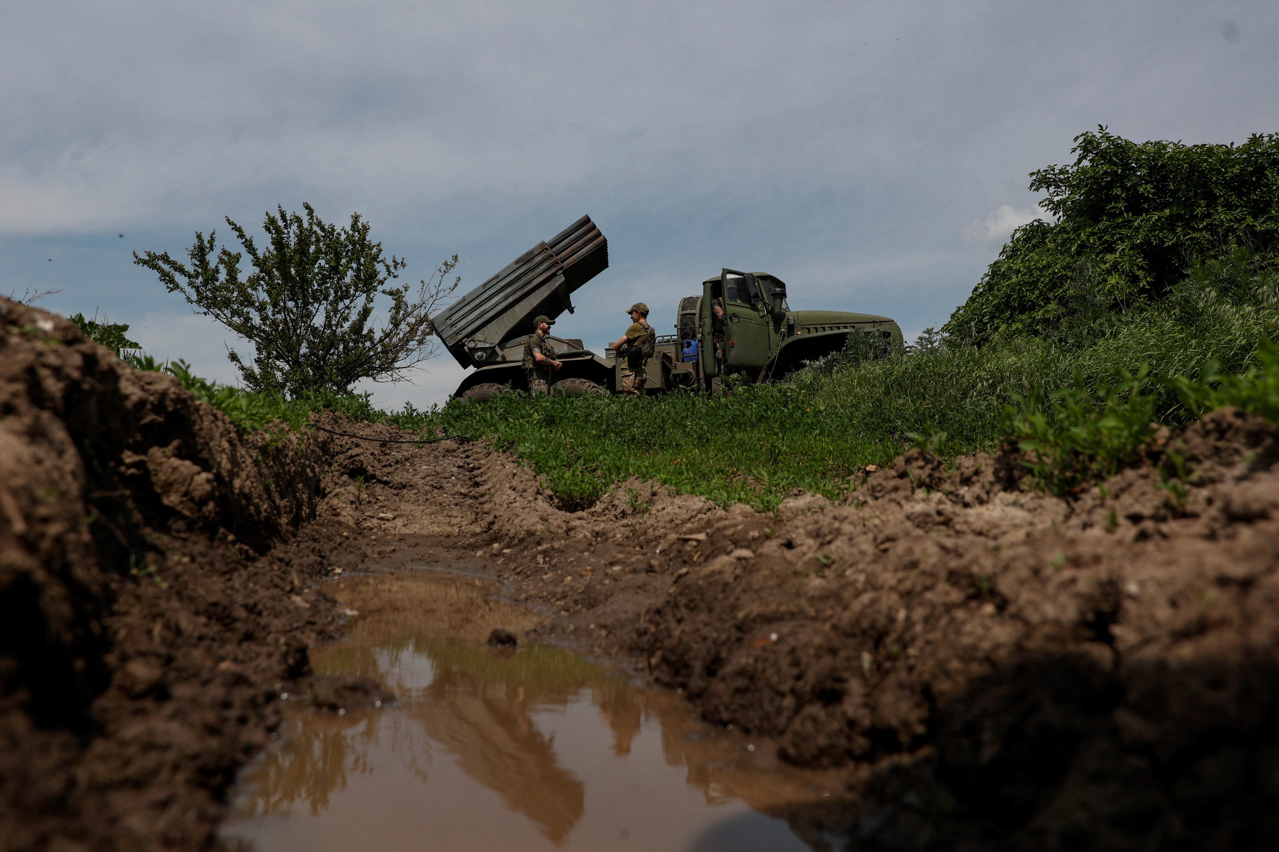 Ukrainian servicemen stand next to a BM-21 Grad multiple launch rocket system to fire towards positions of Russian troops near the frontline town of Bakhmut