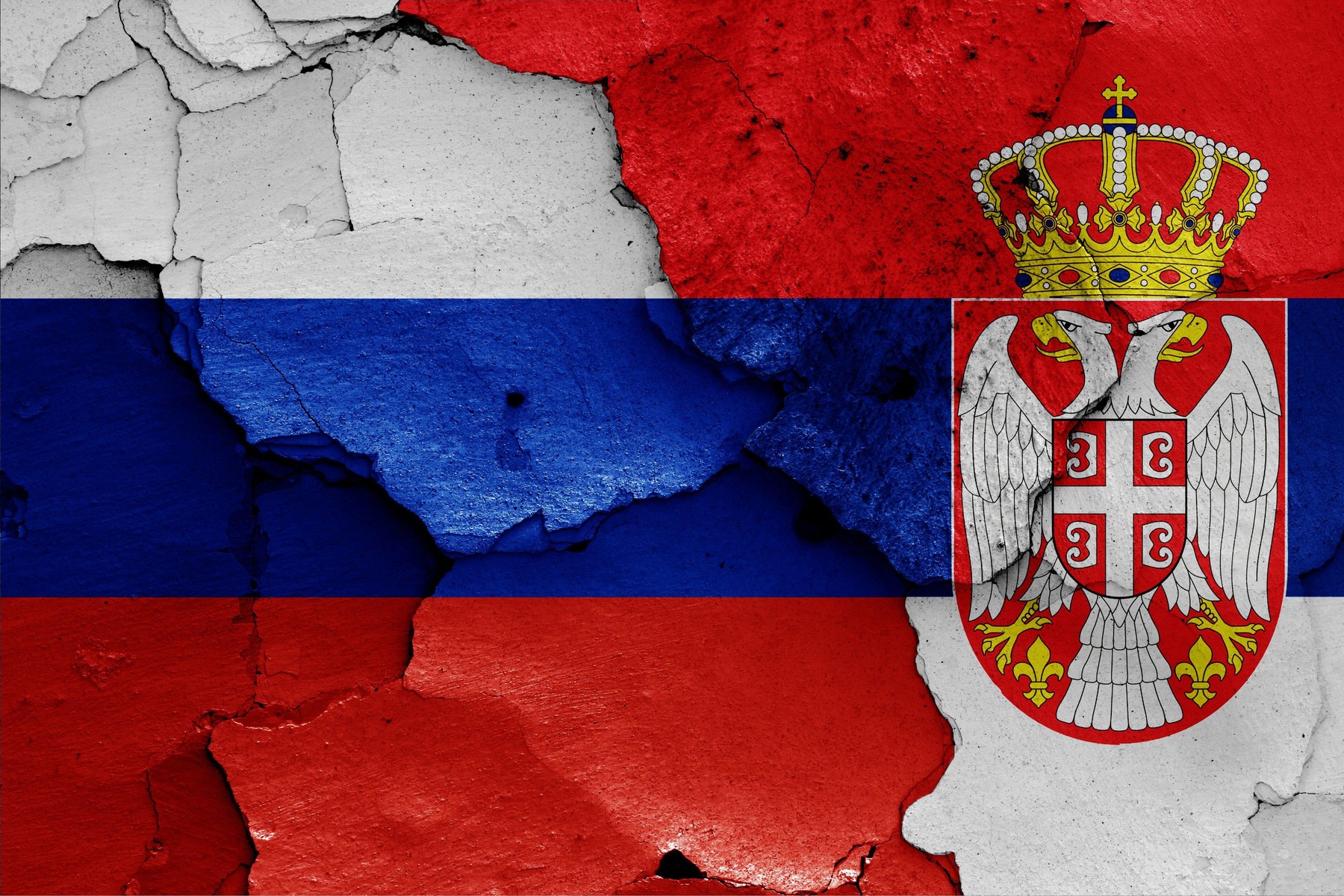 flags of Russia and Serbia painted on cracked wall
