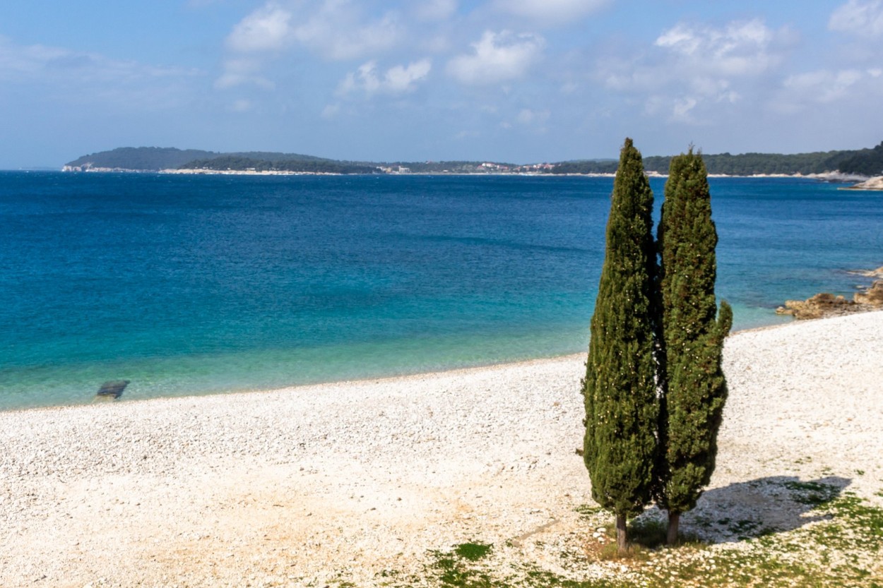 Transparent waters and small round rocks at Ambrela Beach in Verudela near Pula, Croatia