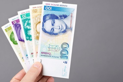 Deutsche money - Mark in the hand on a gray background