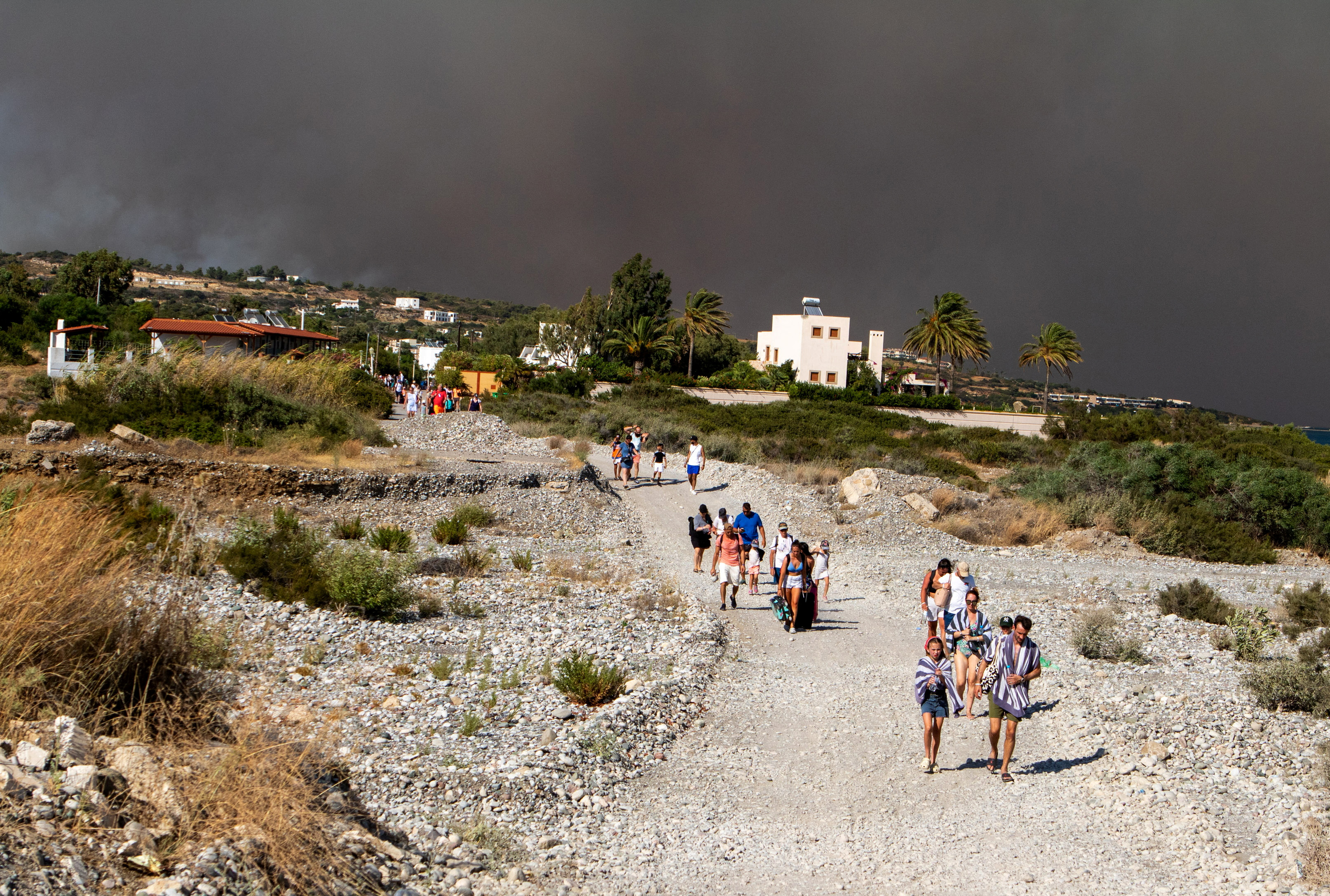 Tourists are being evacuated as wildfire burns near Lindos on the island of Rhodes