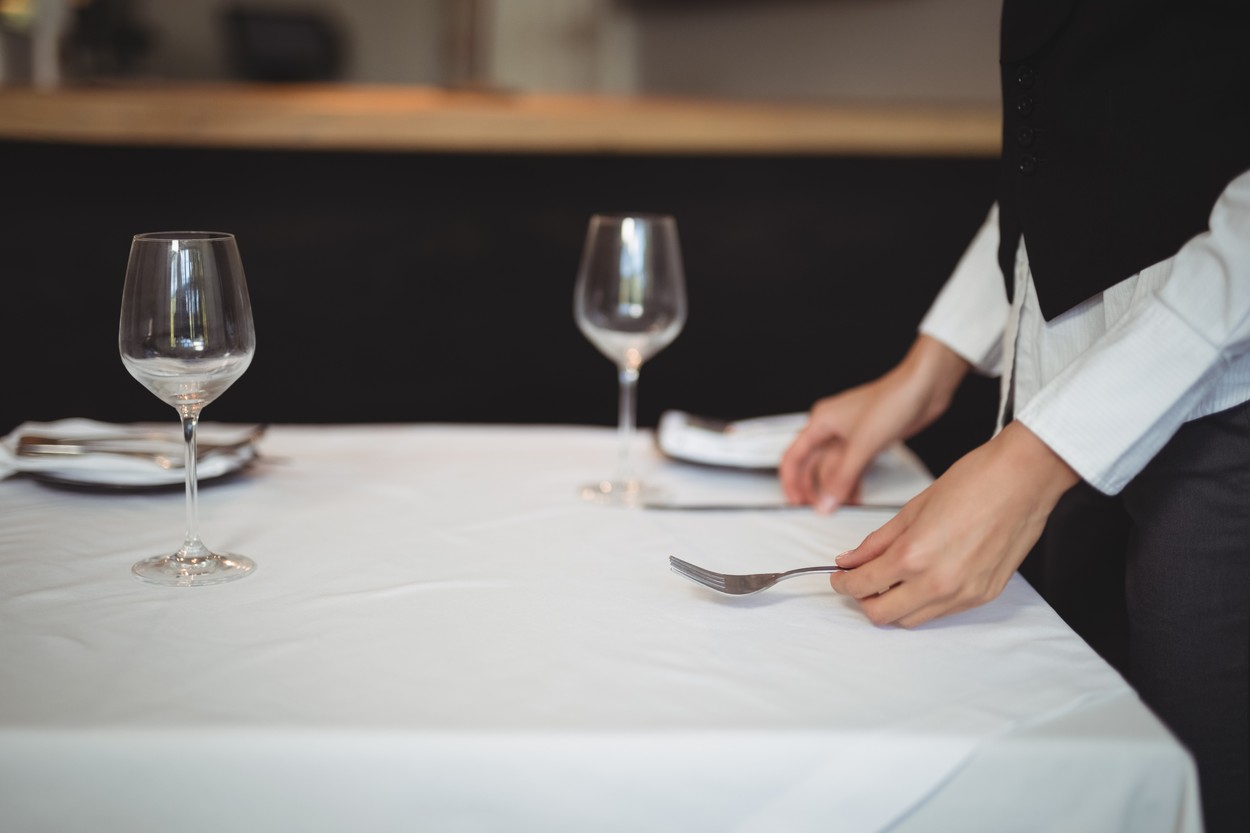 Waitress setting table in restaurant
