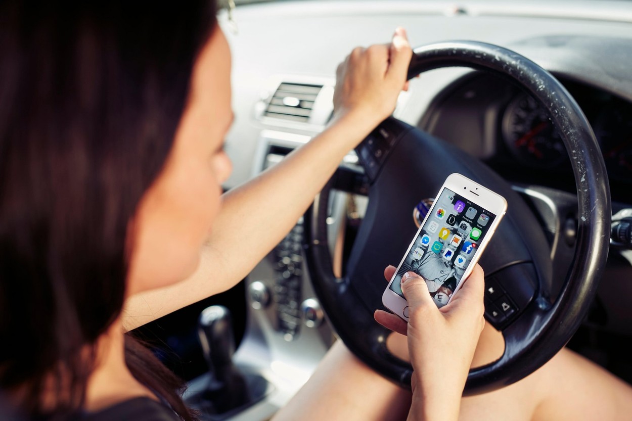 Woman using mobile phone whilst driving