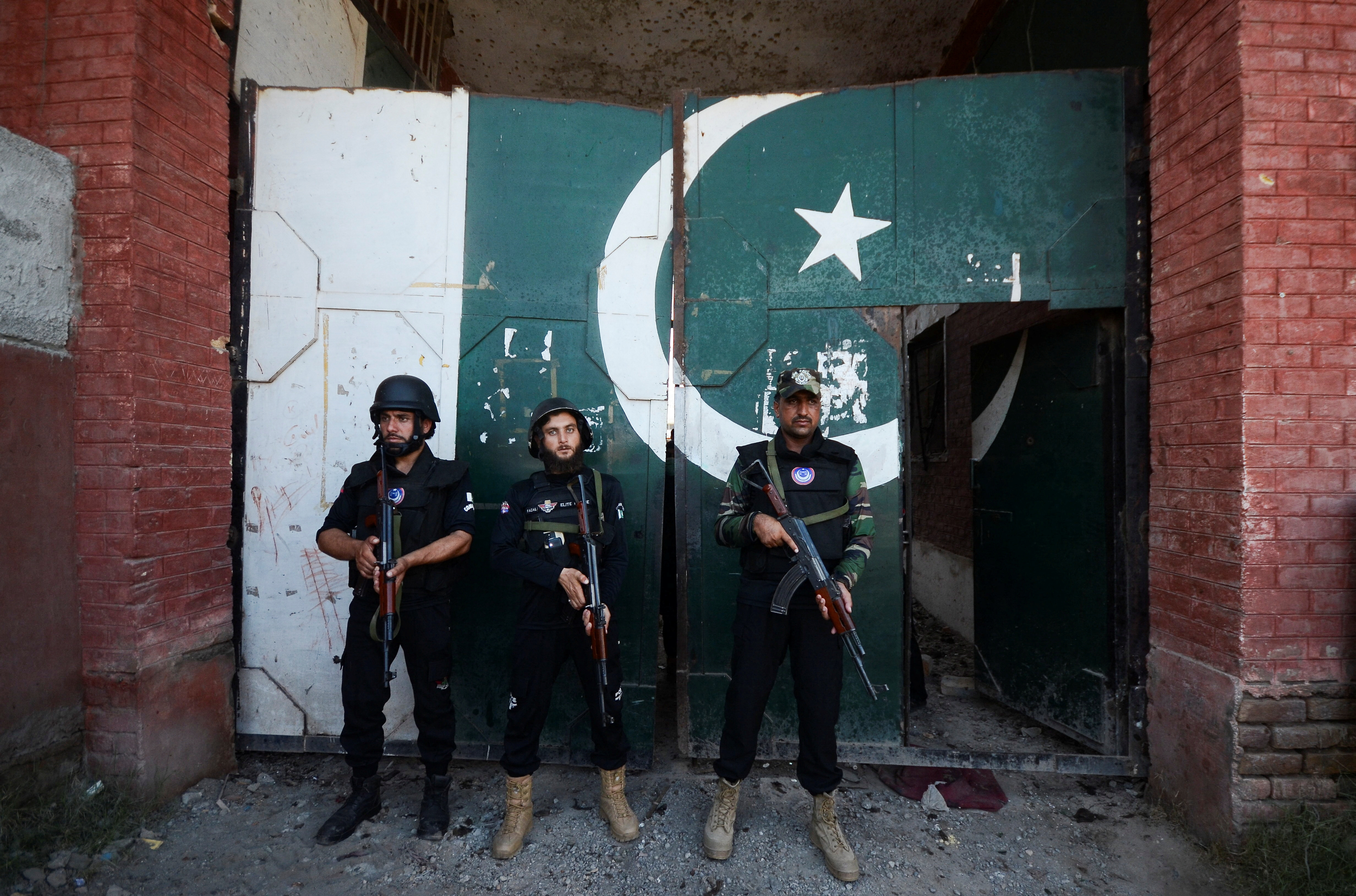 Police officers stand guard at the entrance of a building, after a suicide blast in Bara, on the outskirts of Peshawar
