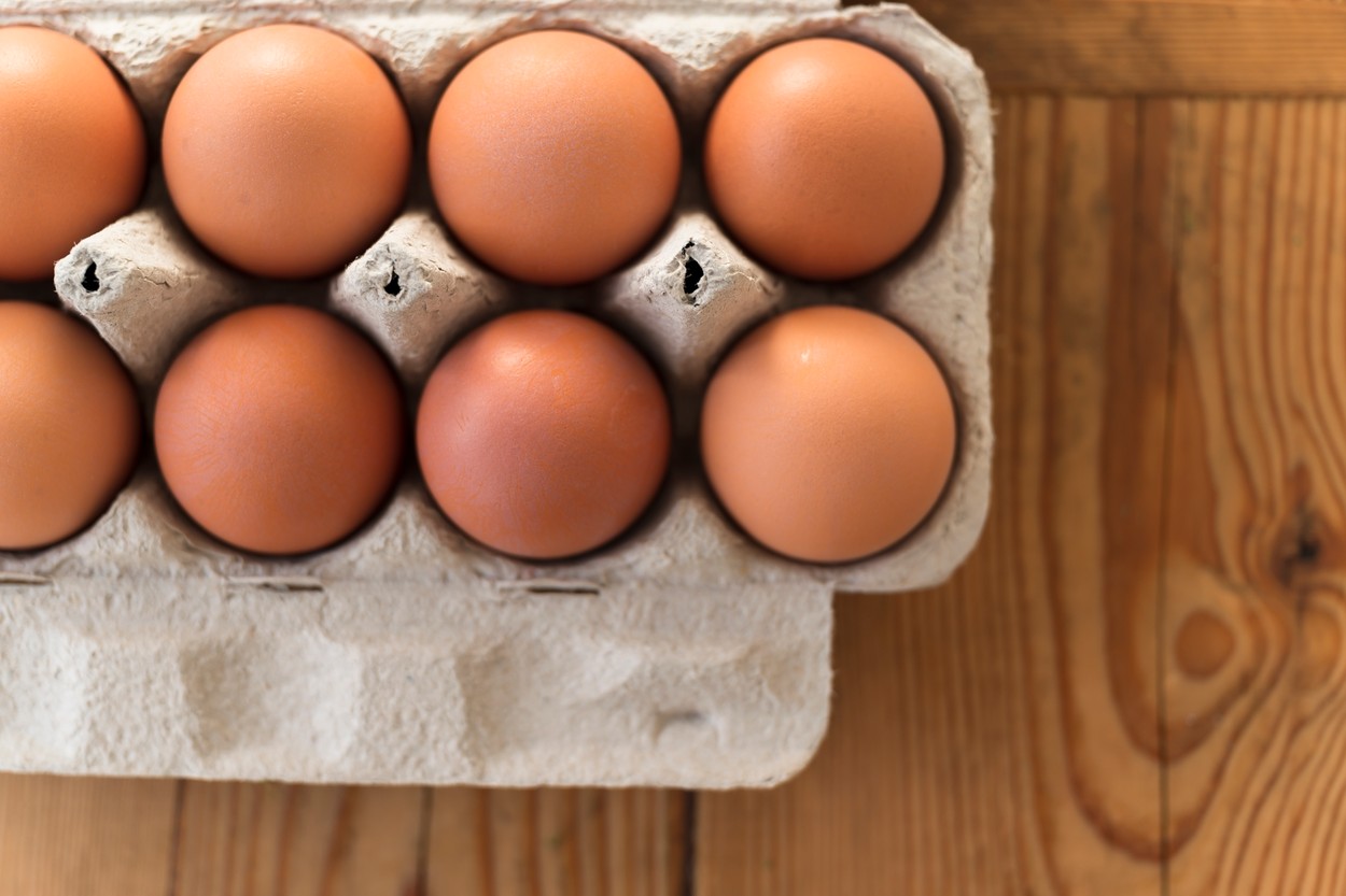 Eggs in carton on wooden table 