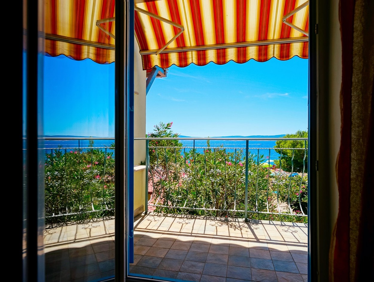 Beautiful view to sea from the inside of apartments. Balcony with marquee. Croatia, sunny day.