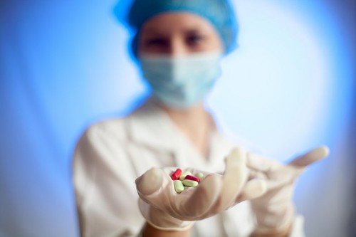 A nurse in a hospital with medication tablets in his hand for the sick, a cure for the disease, a pill of cancer, a treatment for multiple sclerosis a