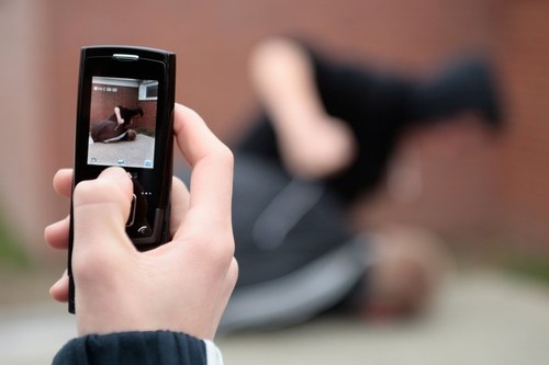 two fighting boys are being recorded by mobile phone