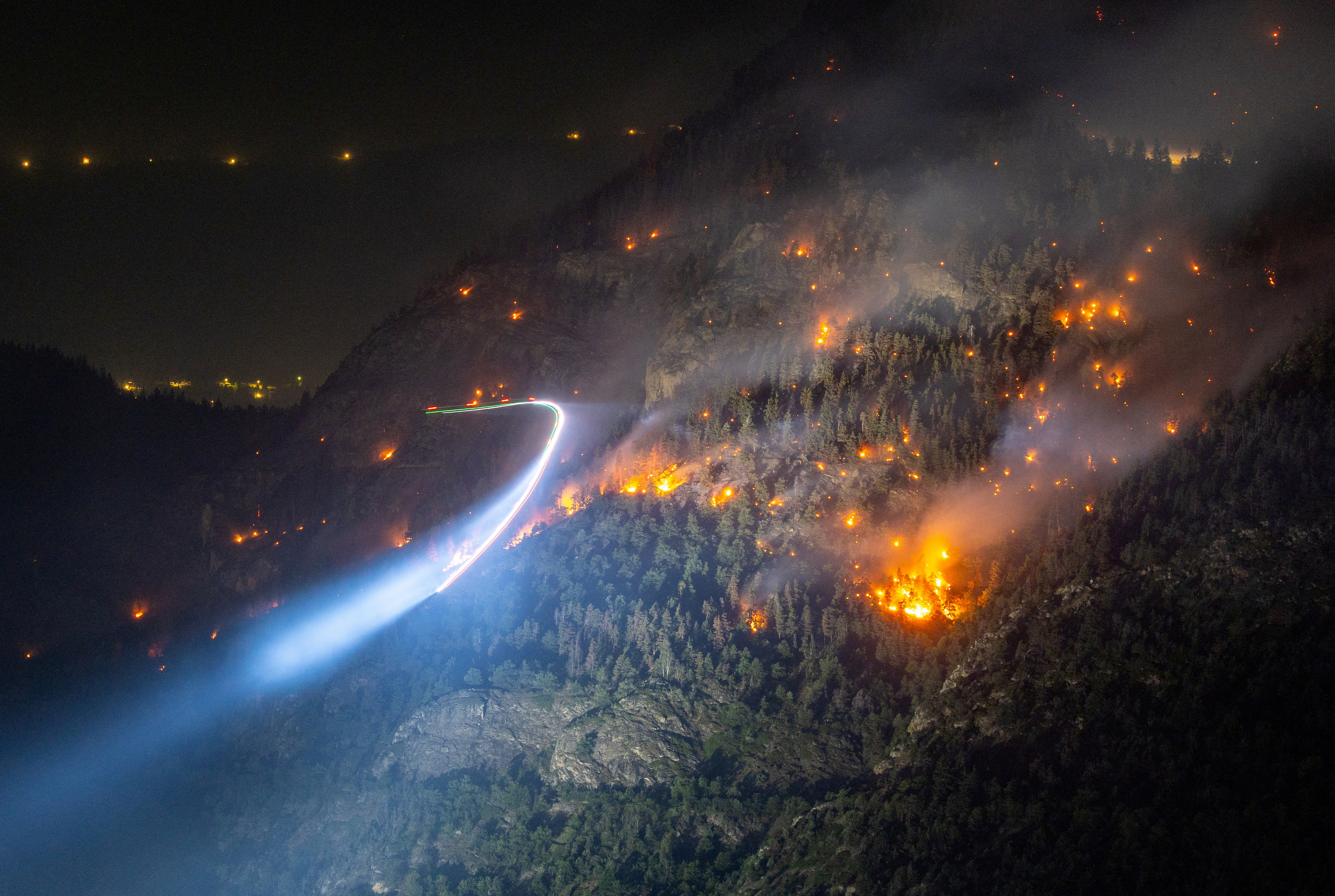 A wildfire spreads on the flank of a mountain in Bitsch