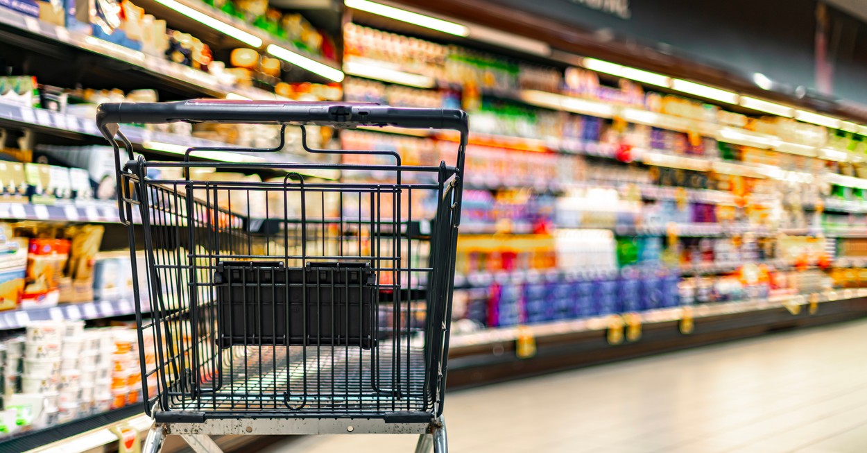 Shopping cart on the background of shop shelves in a supermarket