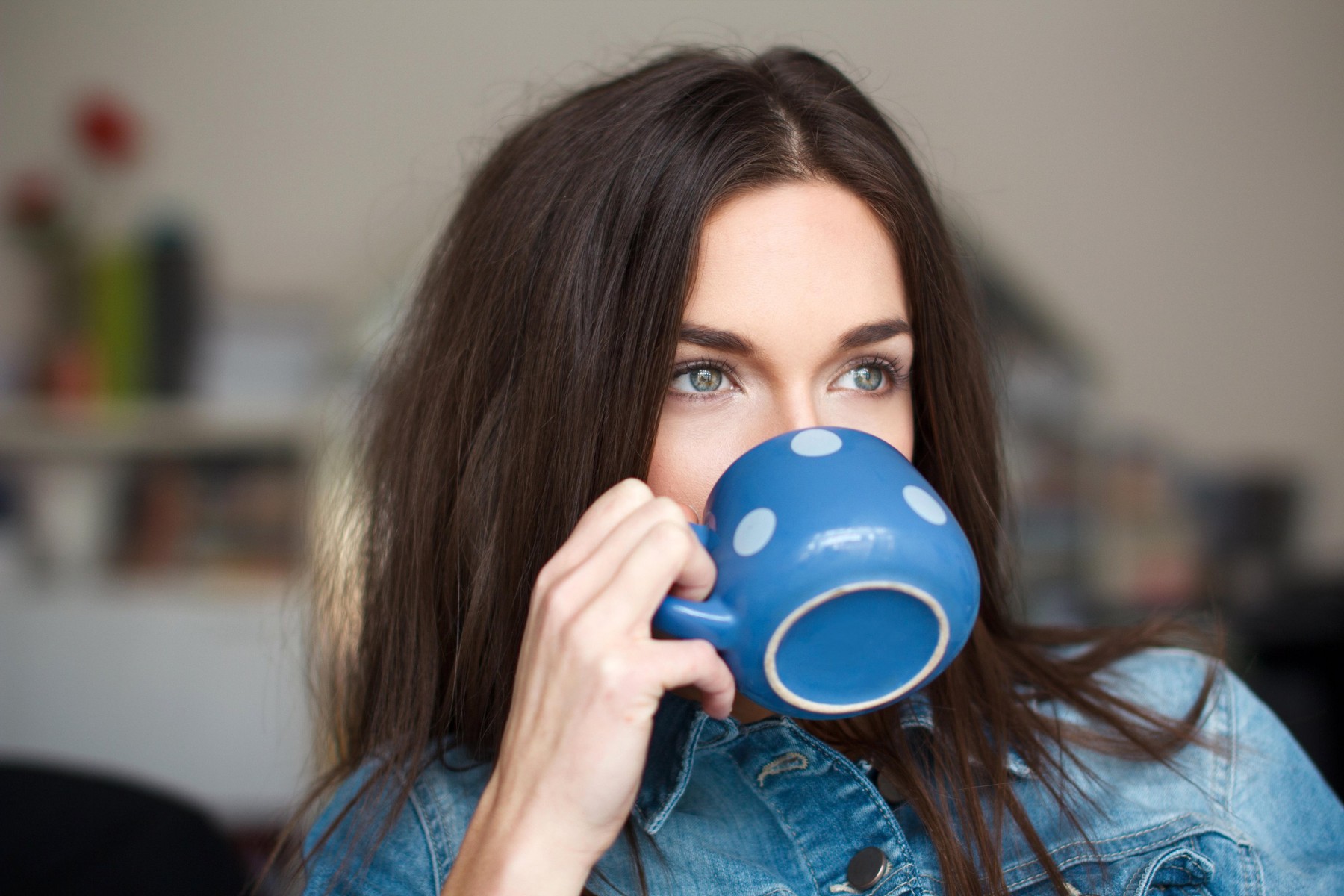 Young white woman drinking refreshment, dotted mug