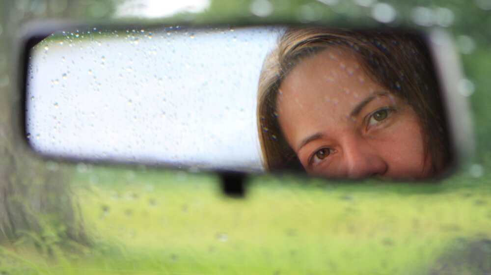 Face of Woman Reflected in Mirror in Car