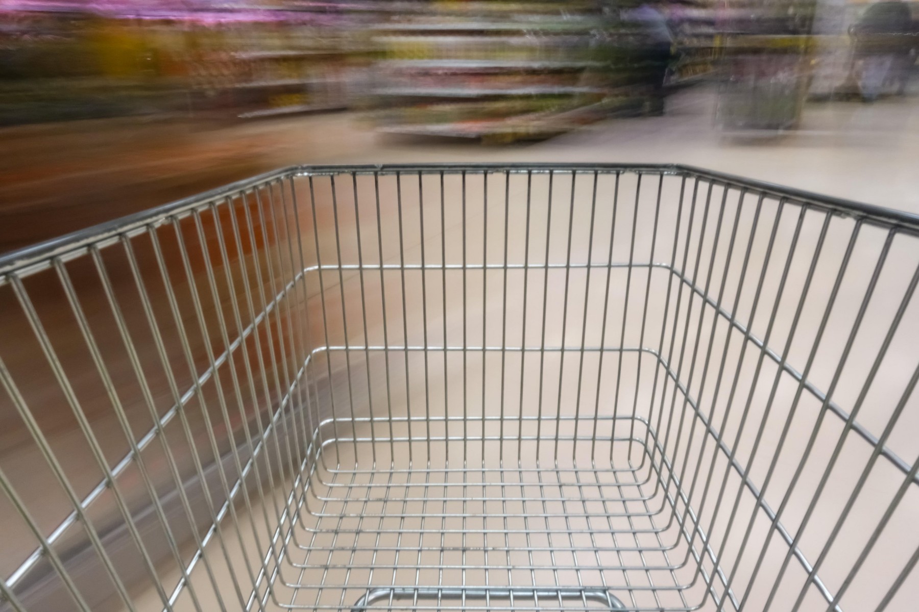 Supermarket aisle with empty shopping cart