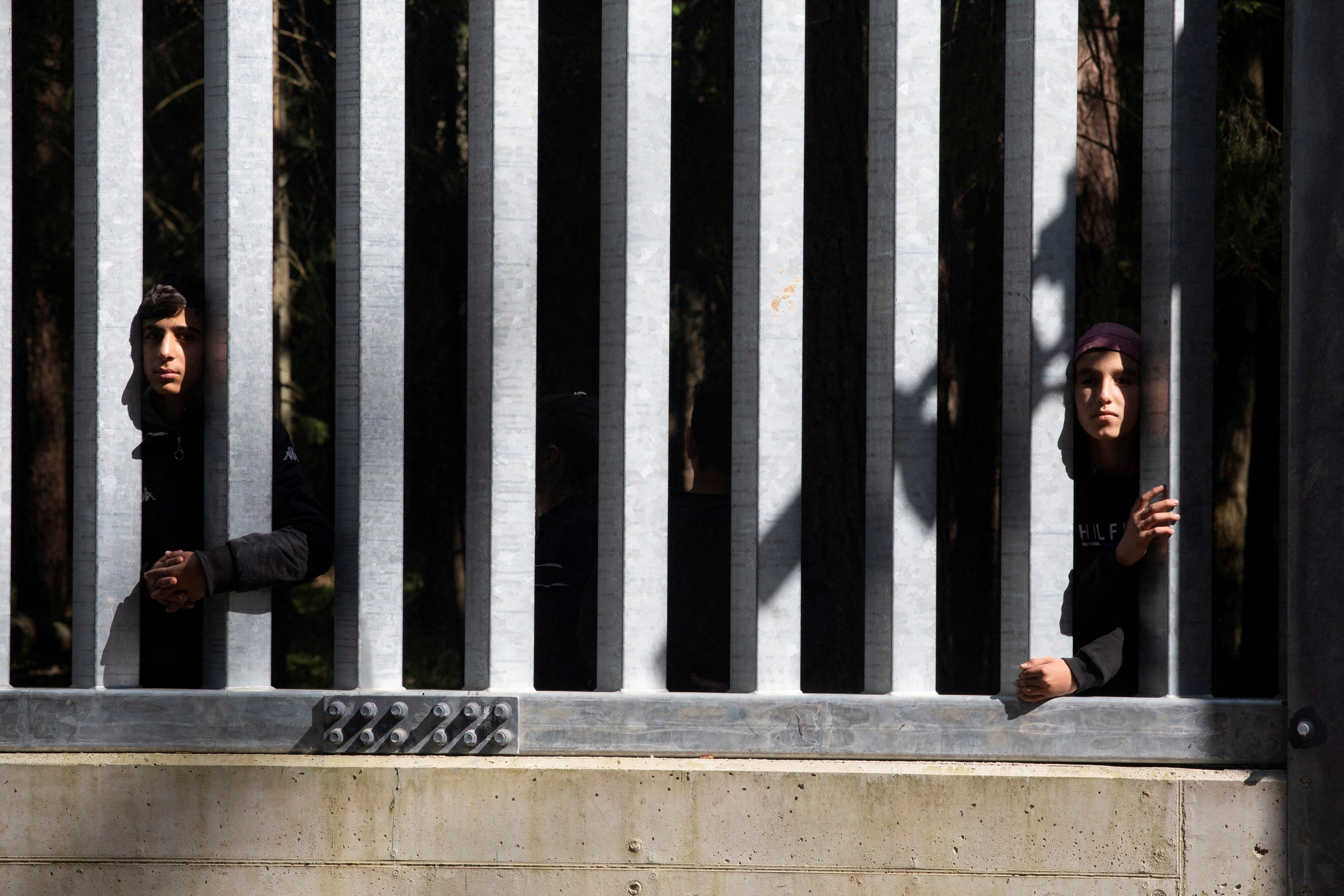 FILE PHOTO: Migrants stand near the wall on Polish Belarusian border near Bialowieza