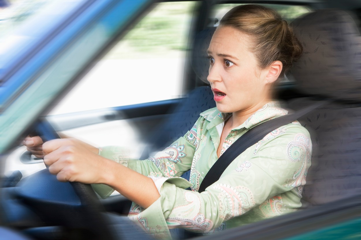 Shocked young woman driving car