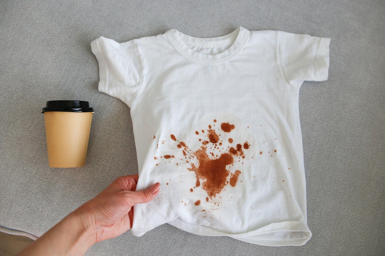The child spilled coffee on his clothes. The concept of a stain on a t-shirt. Top view.