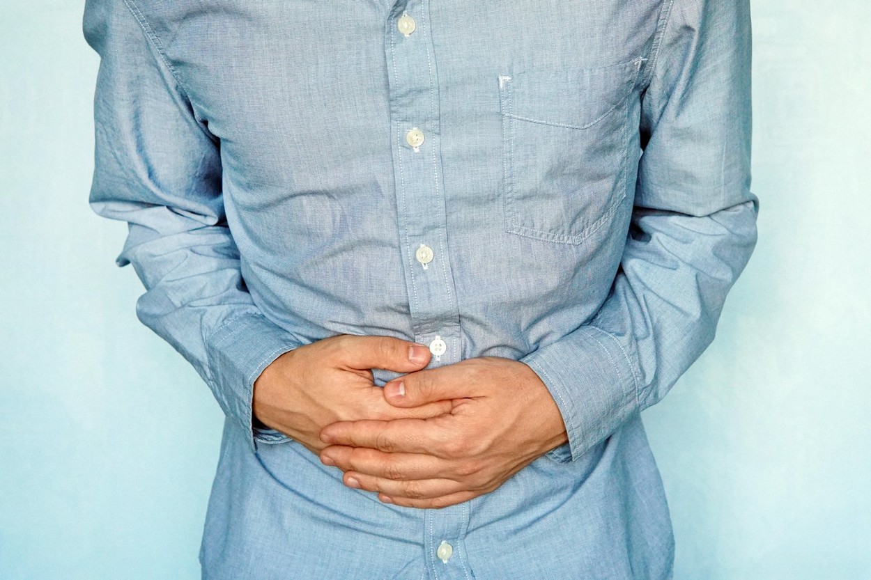 Businessman holding his stomach in pain. heaviness in the stomach after eating. diseases of the gastrointestinal tract. gases in the stomach. stomach