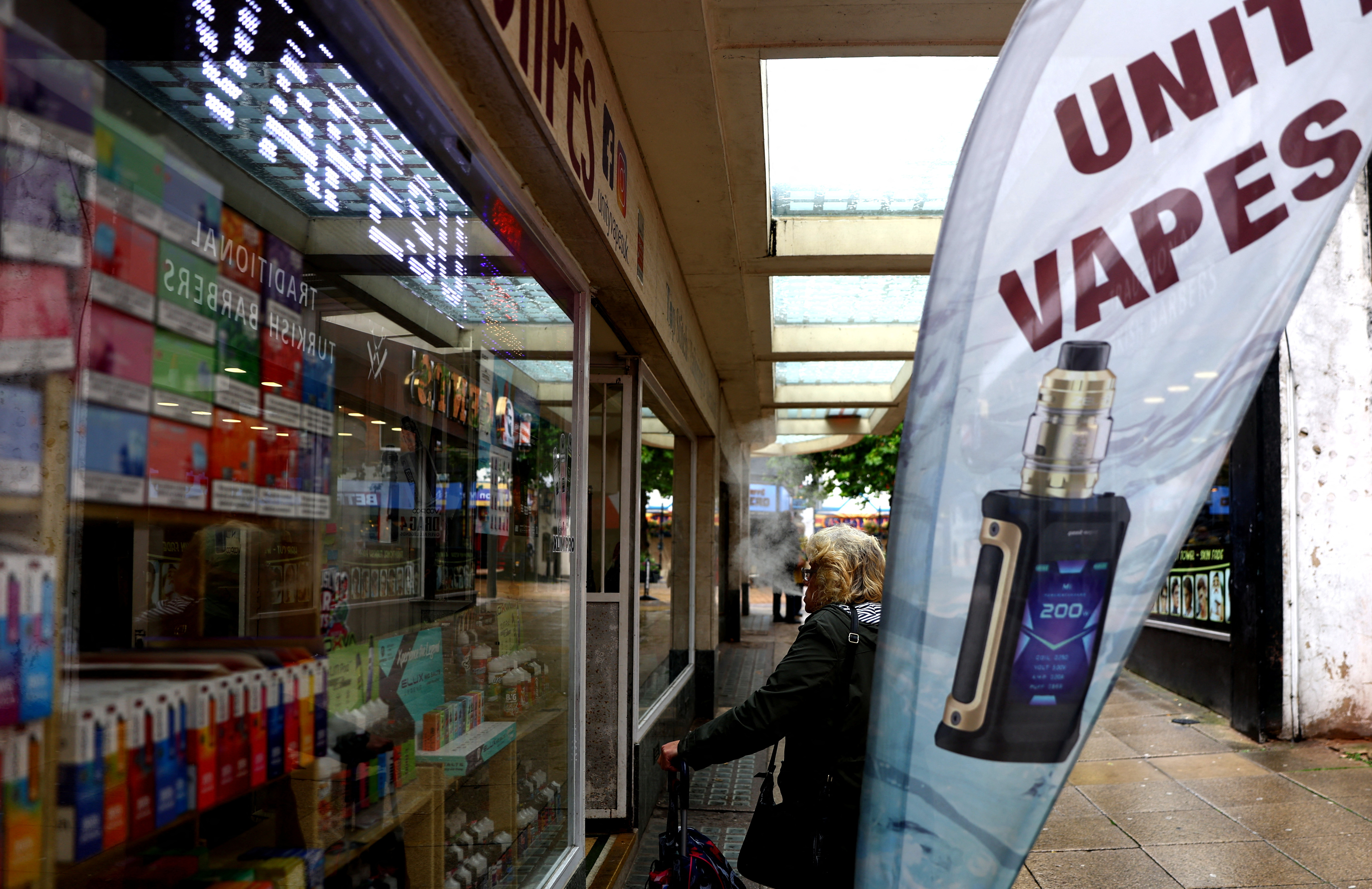 A lady looks into a vape shop in Newcastle-under-Lyme
