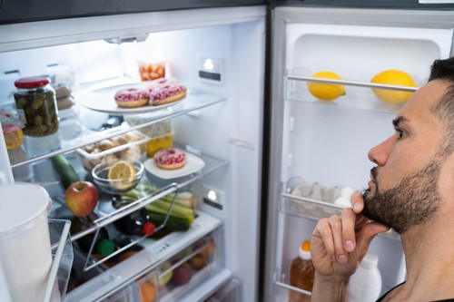 Hungry Confused Man Looking In Open Fridge