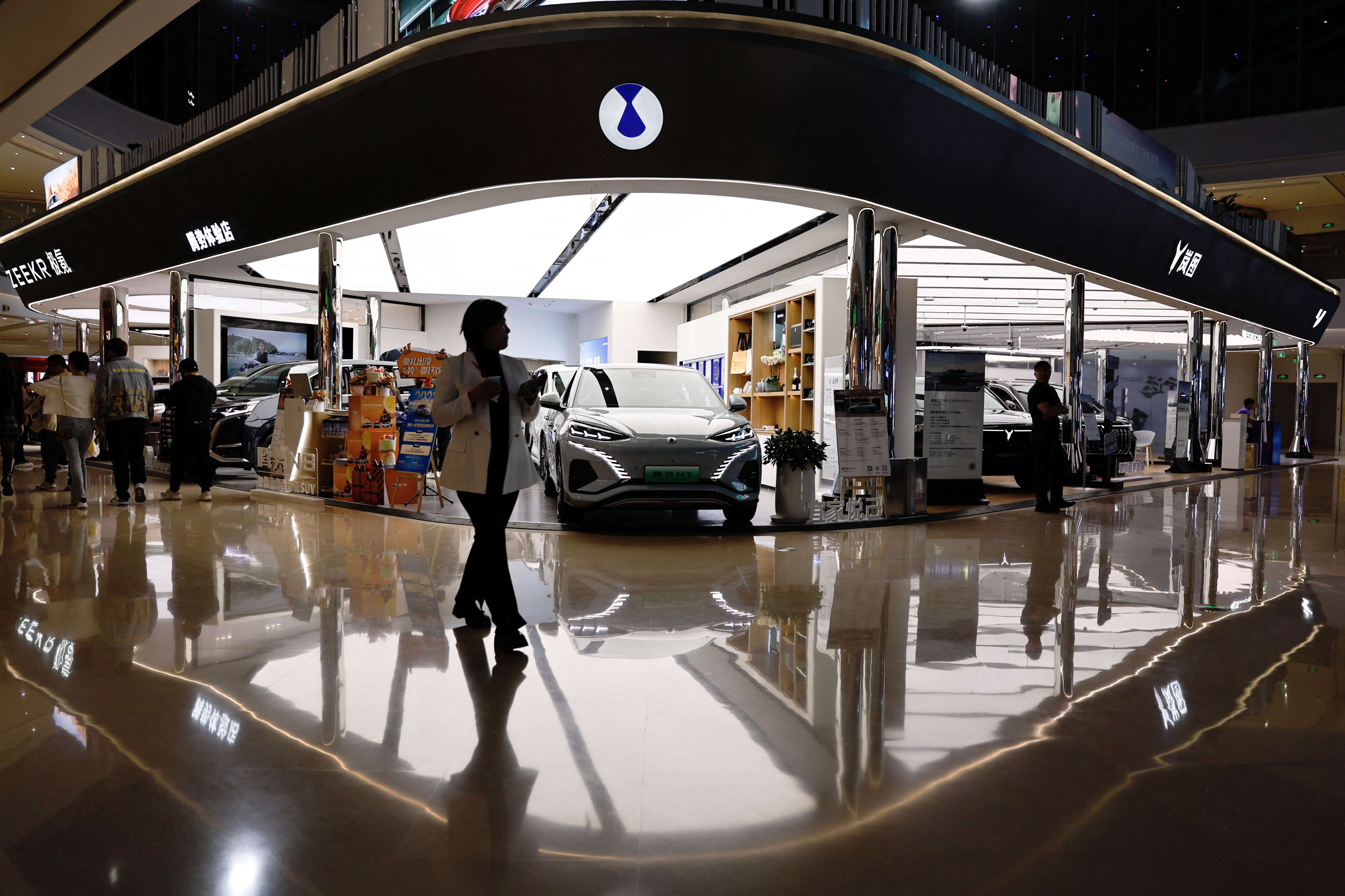Electric vehicle (EV) models are displayed at the booth of Denza, a joint venture between Mercedes-Benz Group AG and BYD Auto, in Beijing