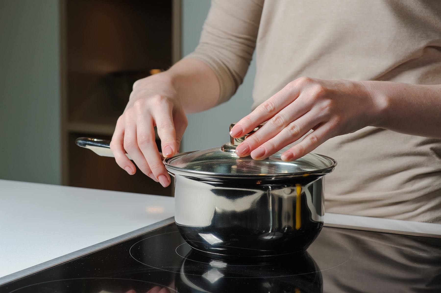 Person removing lid from cooking pot