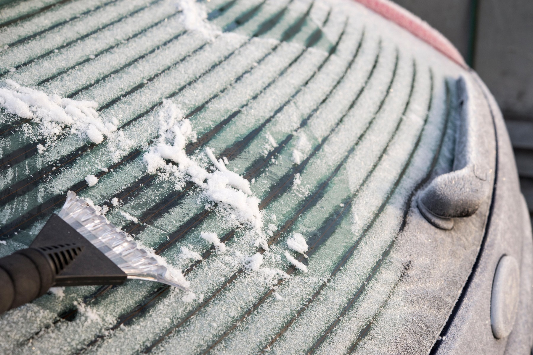 Defrosting a rear car windscreen on a frosty winter morning in England.