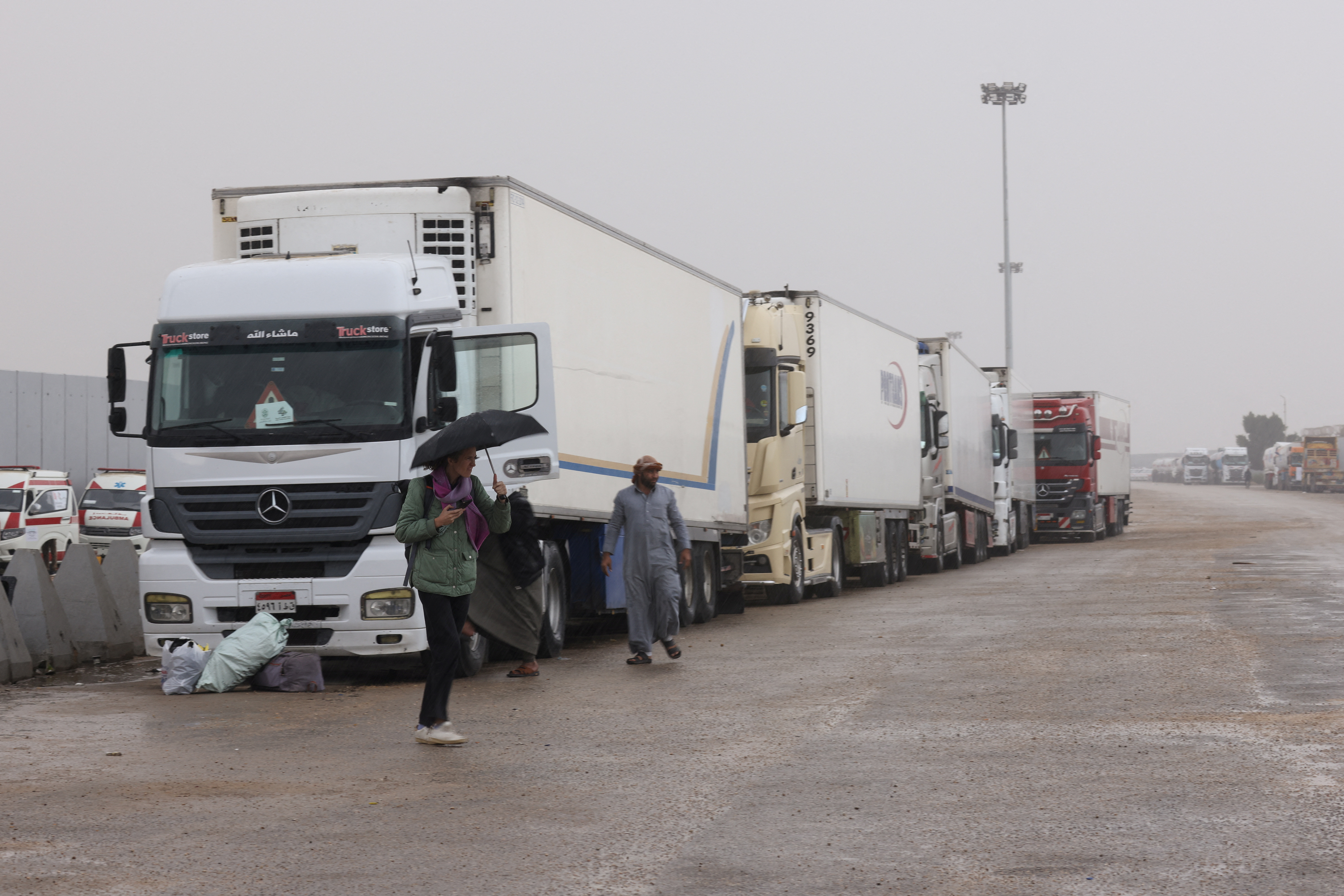 Trucks transporting humanitarian aid wait at the Rafah border crossing