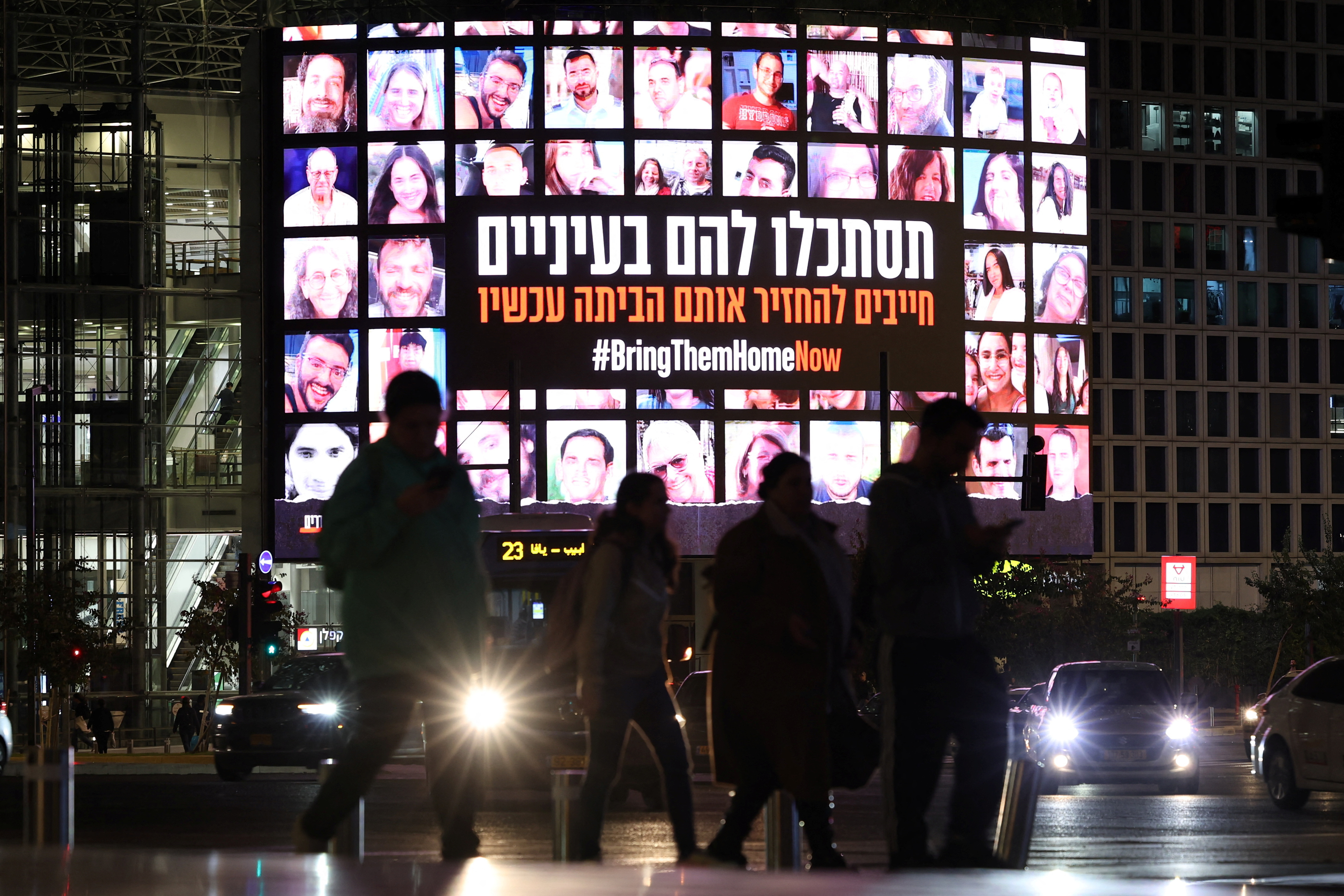 A screen displays photos of people who were abducted by Hamas gunmen during the October 7 attack on Israel, in Tel Aviv