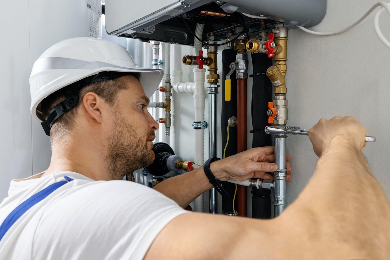 worker installing pipes of house gas heating boiler