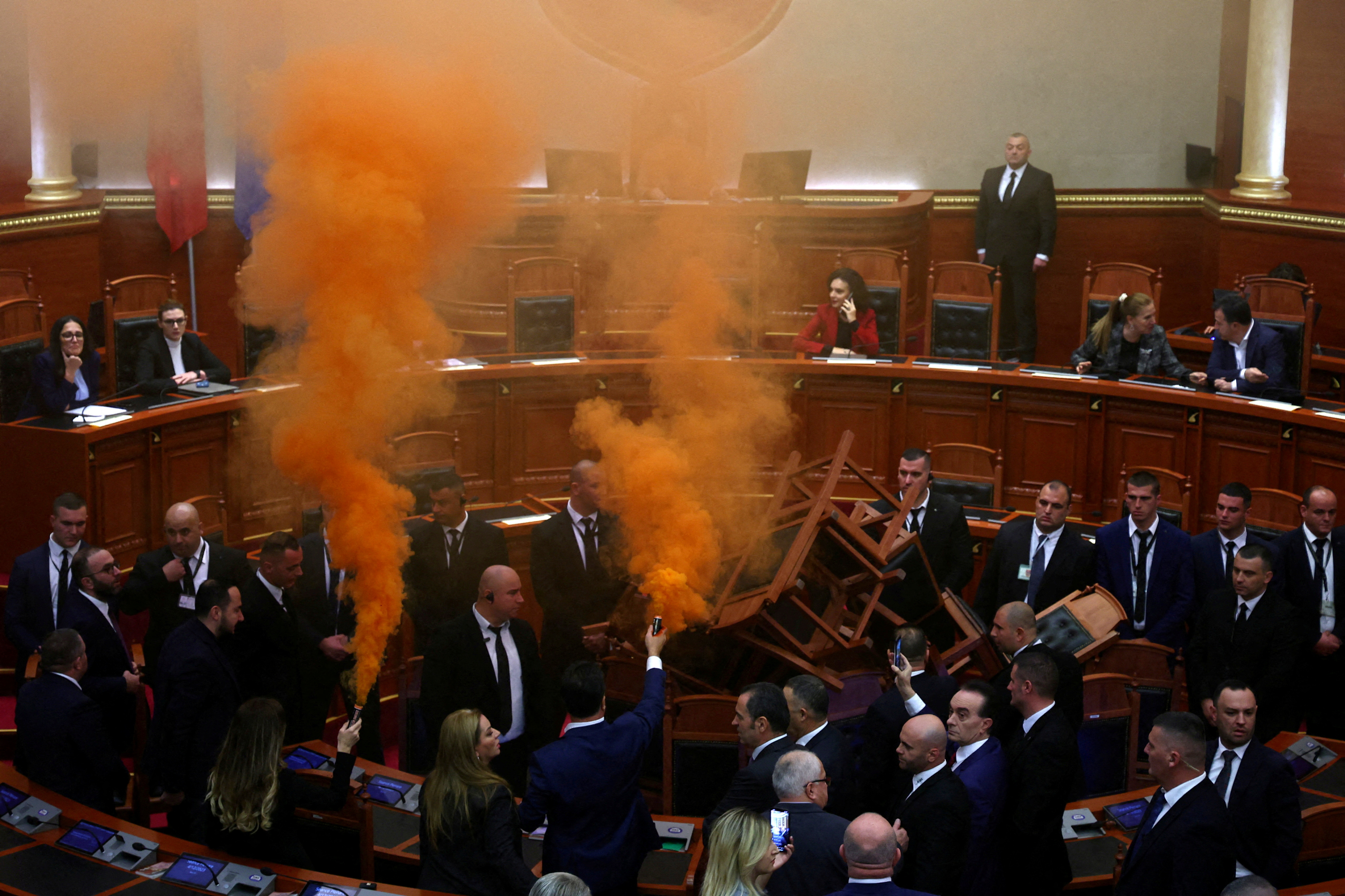 MPs of Democratic Party light coloured smoke bombs during a parliament session in Tirana